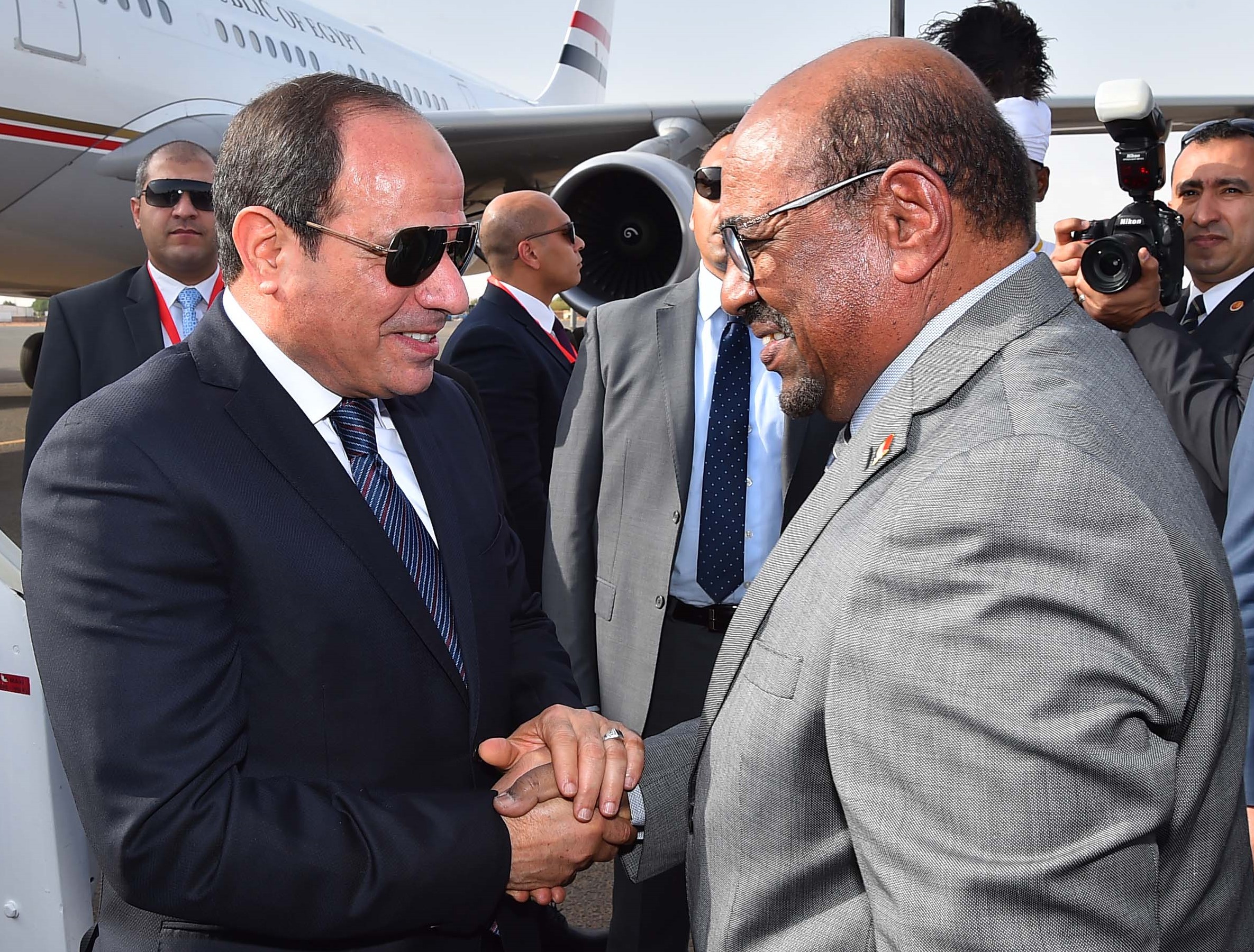 Le président soudanais Omar el-Béchir (à&nbsp;droite) salue son homologue égyptien Abdel Fattah al-Sissi à son arrivée à l’aéroport international de Khartoum, le 19&nbsp;juillet&nbsp;2018 (AFP)