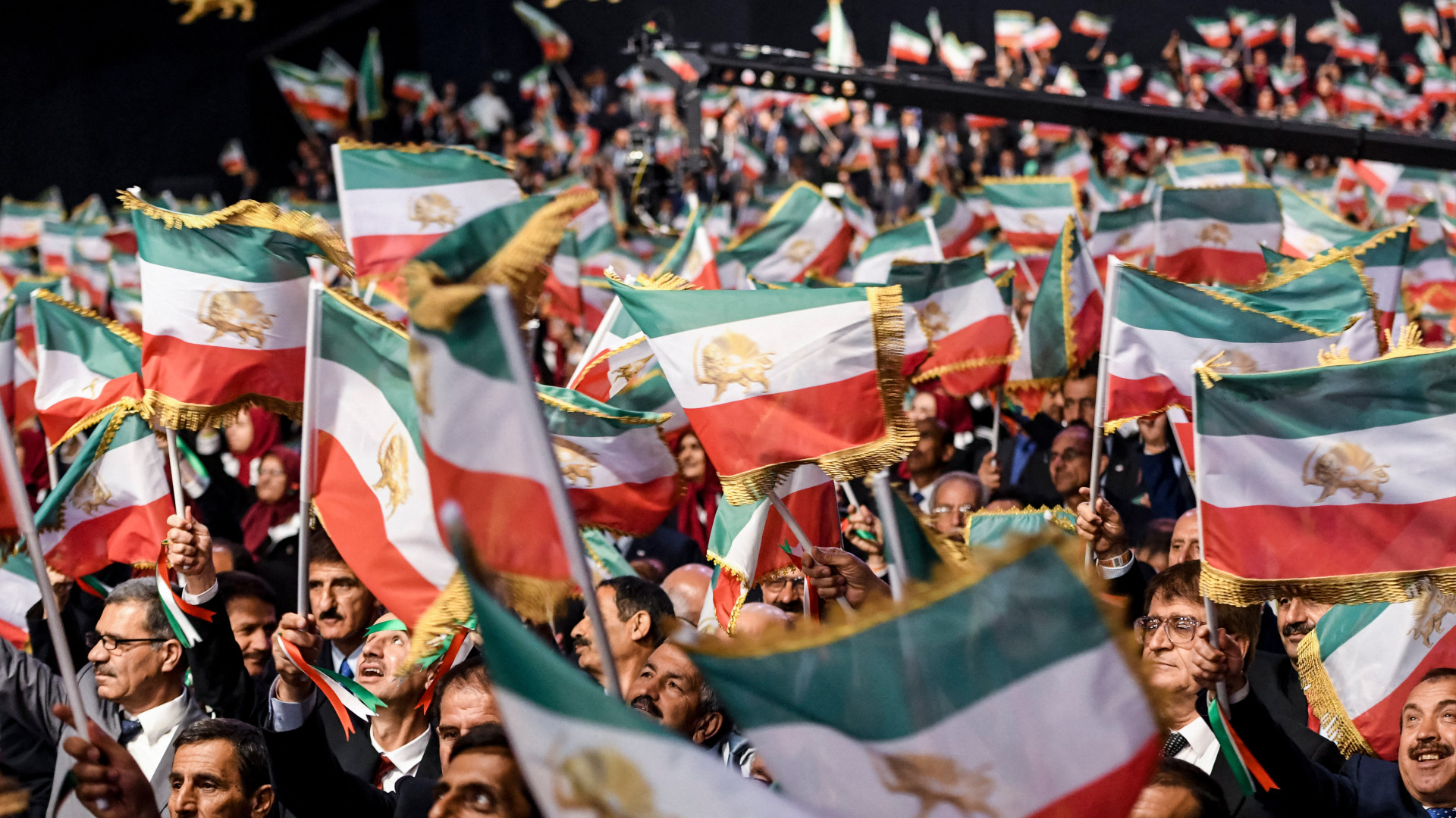 Mujahedin-e Khalq members waves Iranian flags during the conference 