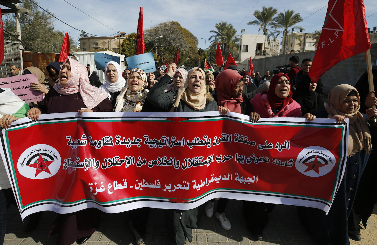 Palestinian demonstrators carry a banner from Gaza's Democratic Front for the Liberation of Palestine group denouncing the latest Middle East peace plan by US President Donald Trump (AFP)
