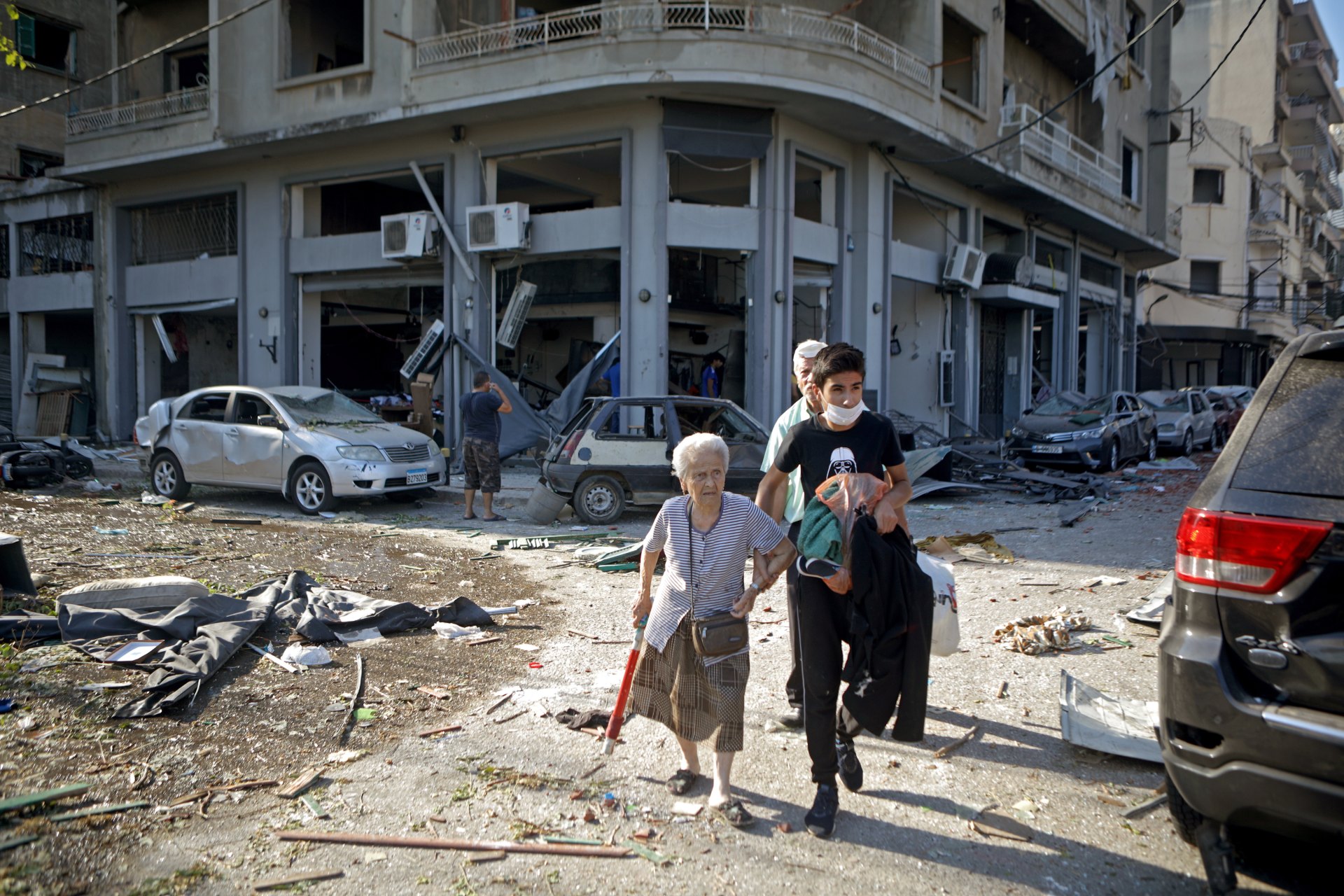 A woman is evacuated from the partially destroyed Beirut neighbourhood of Mar Mikhael on Wednesday in the aftermath of a massive explosion in the Lebanese capital (AFP)