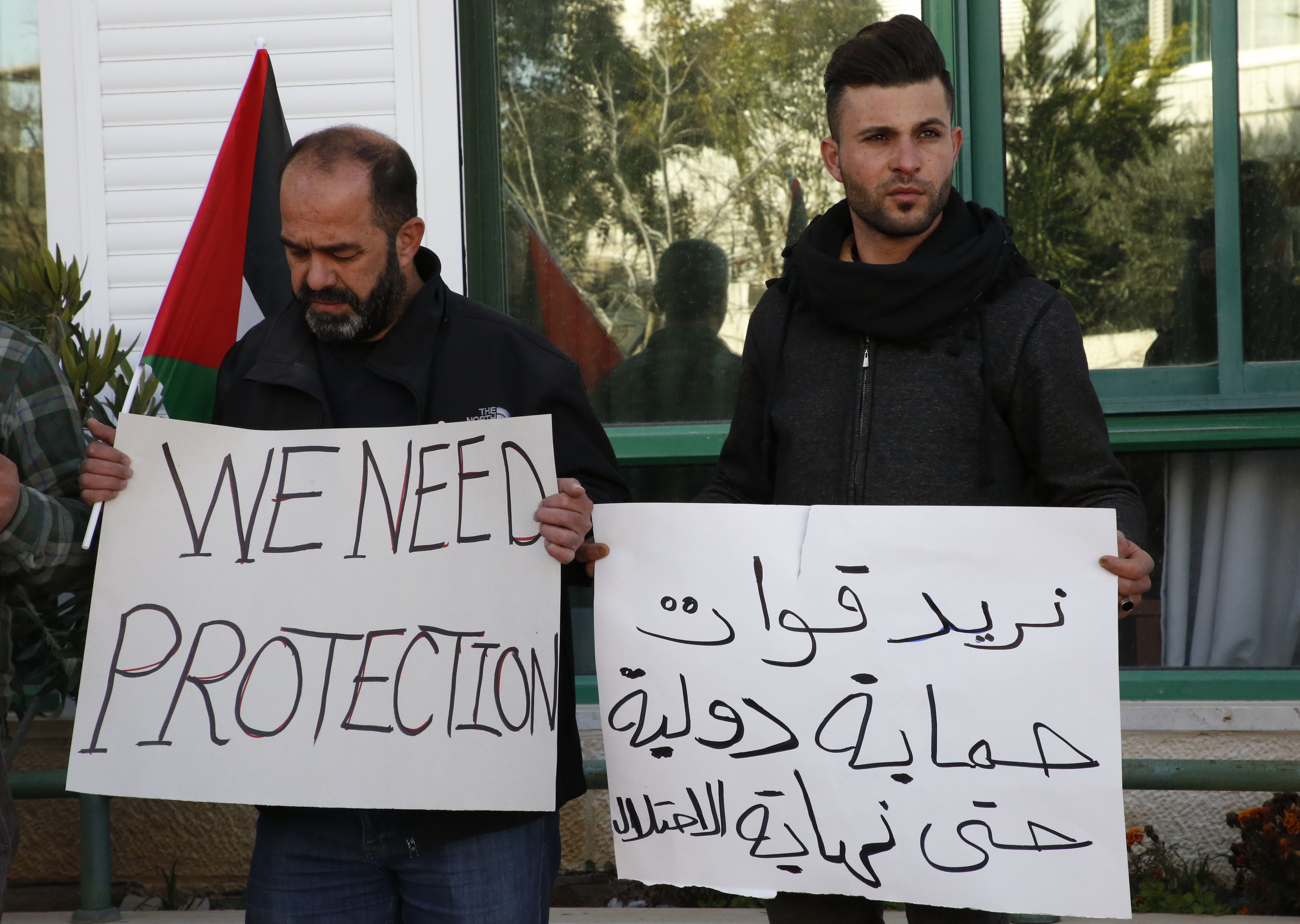  Palestinians carry placards denouncing the Israeli prime minister's recent decision not to renew the mendate of The Temporary International Presence in Hebron (TIPH) on 30 January (AFP)