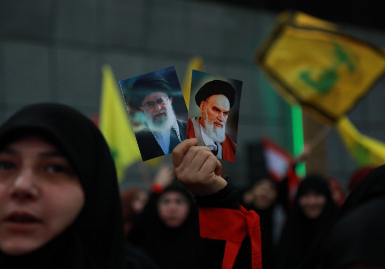 Hezbollah supporters hold images of Ayatollah Ruhollah Khomeini and Ayatollah Ali Khamenei during celebrations marking the 40th anniversary of the Iranian revolution in Beirut on 6 February (AFP)