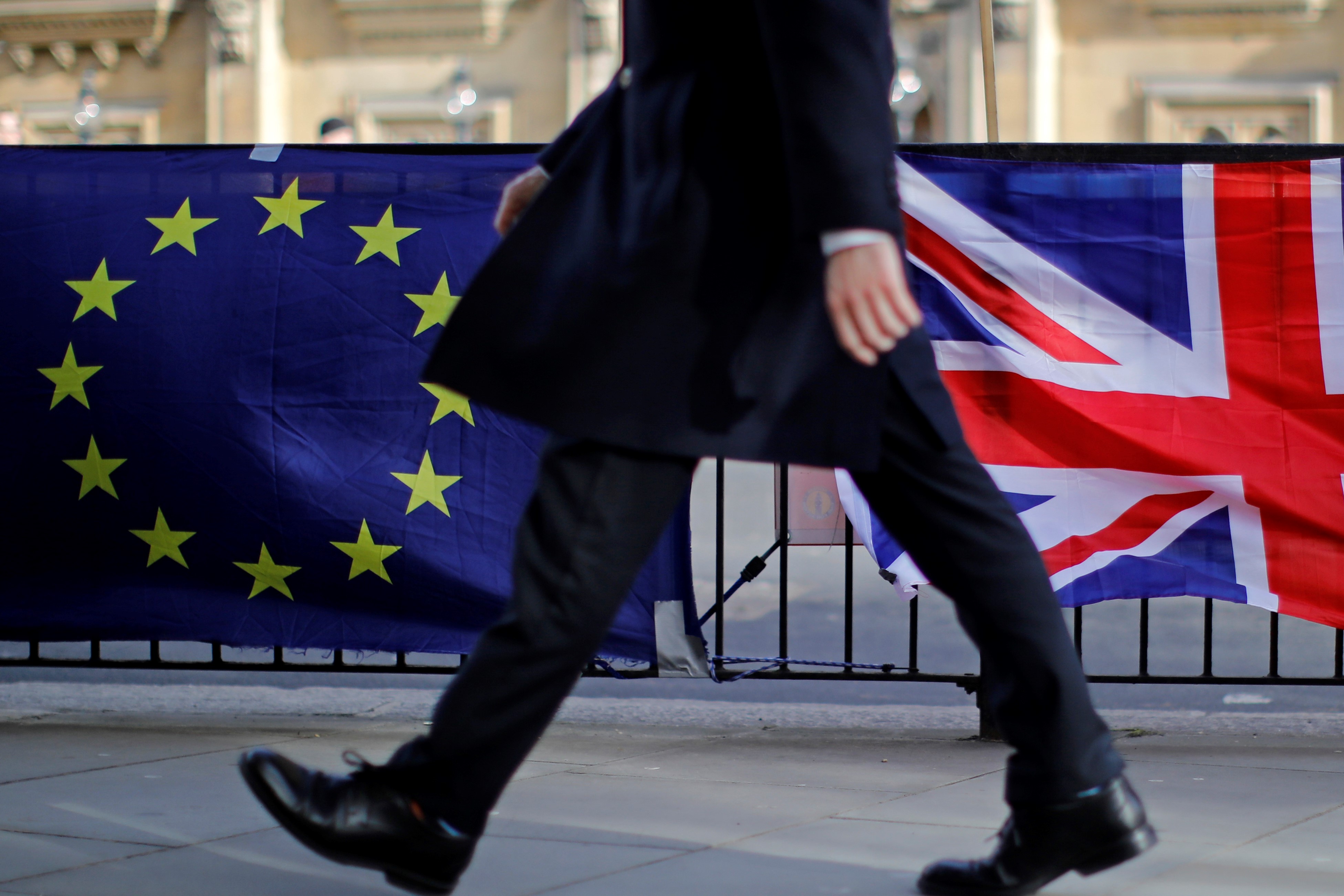 A man walks past the flags of Anti-Brexit protesters outside the Houses of Parliament in London on 12 February, 2019 (AFP)