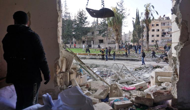 A Syrian man checks the scene of an attack in Idlib, Syria, on 18 February (AFP)