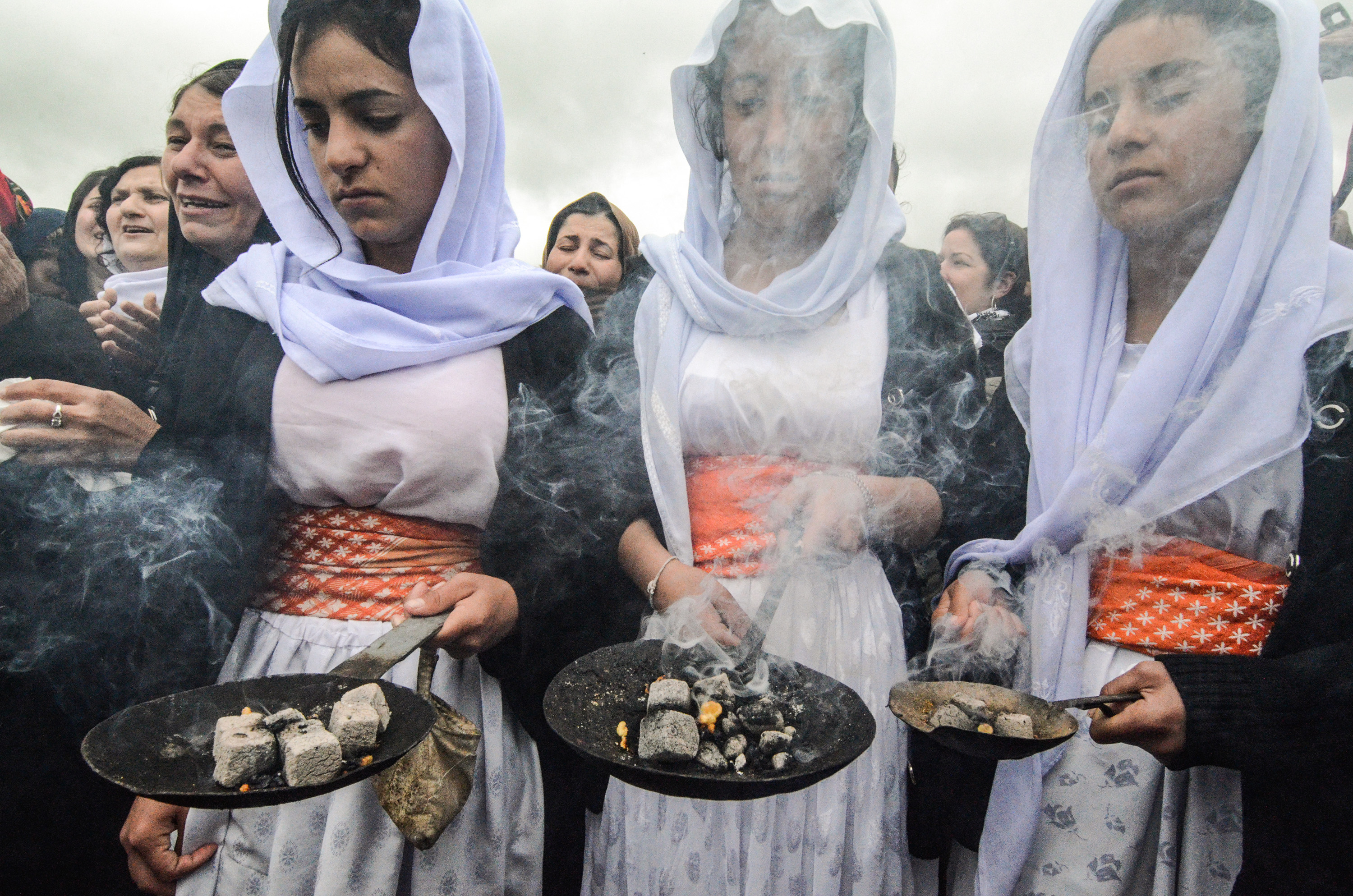 Iraqi Yazidis take part in a ceremony during the exhumation of a mass-grave of hundreds of Yazidis killed by Islamic State (IS) group militants in the northern Iraqi village of Kojo (AFP)