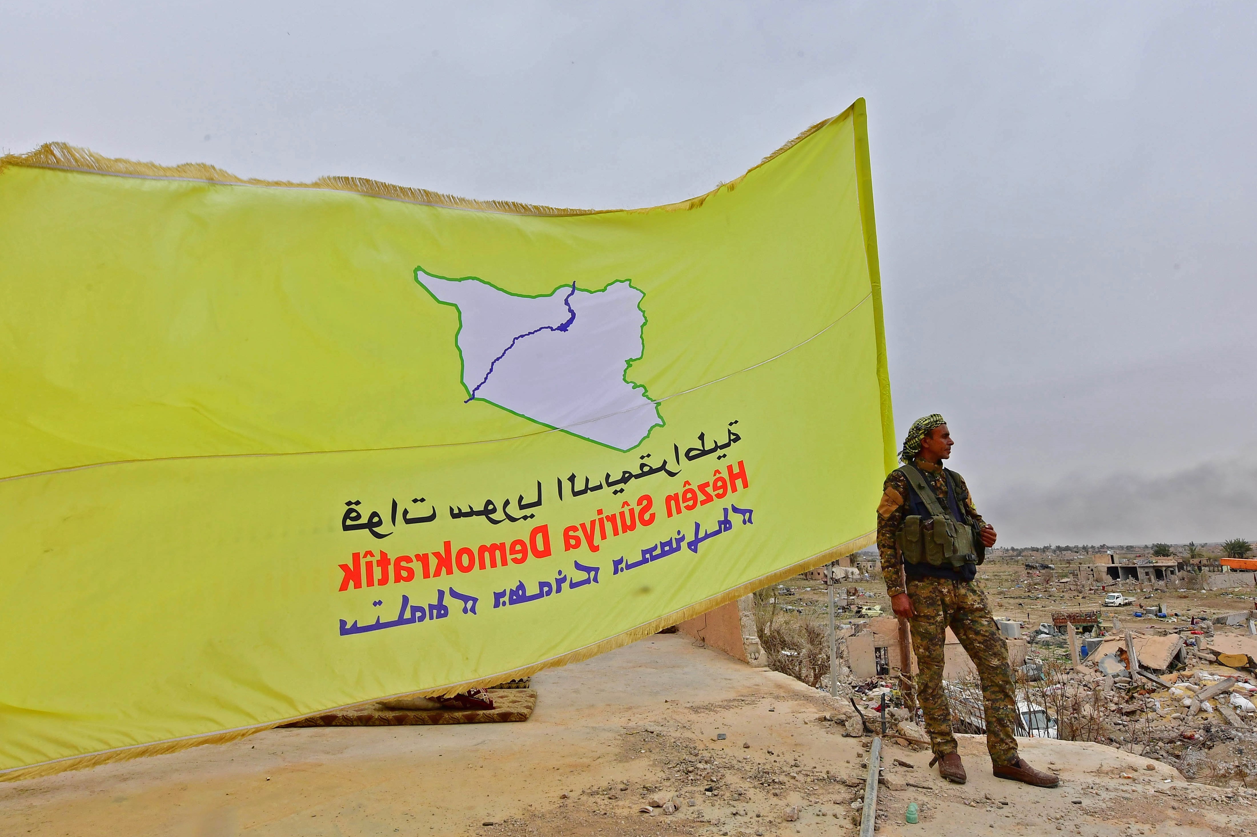   A member of the Syrian Democratic Forces (SDF) on watch duty in Syria's eastern Deir Ezzor province 24 March (AFP) 
