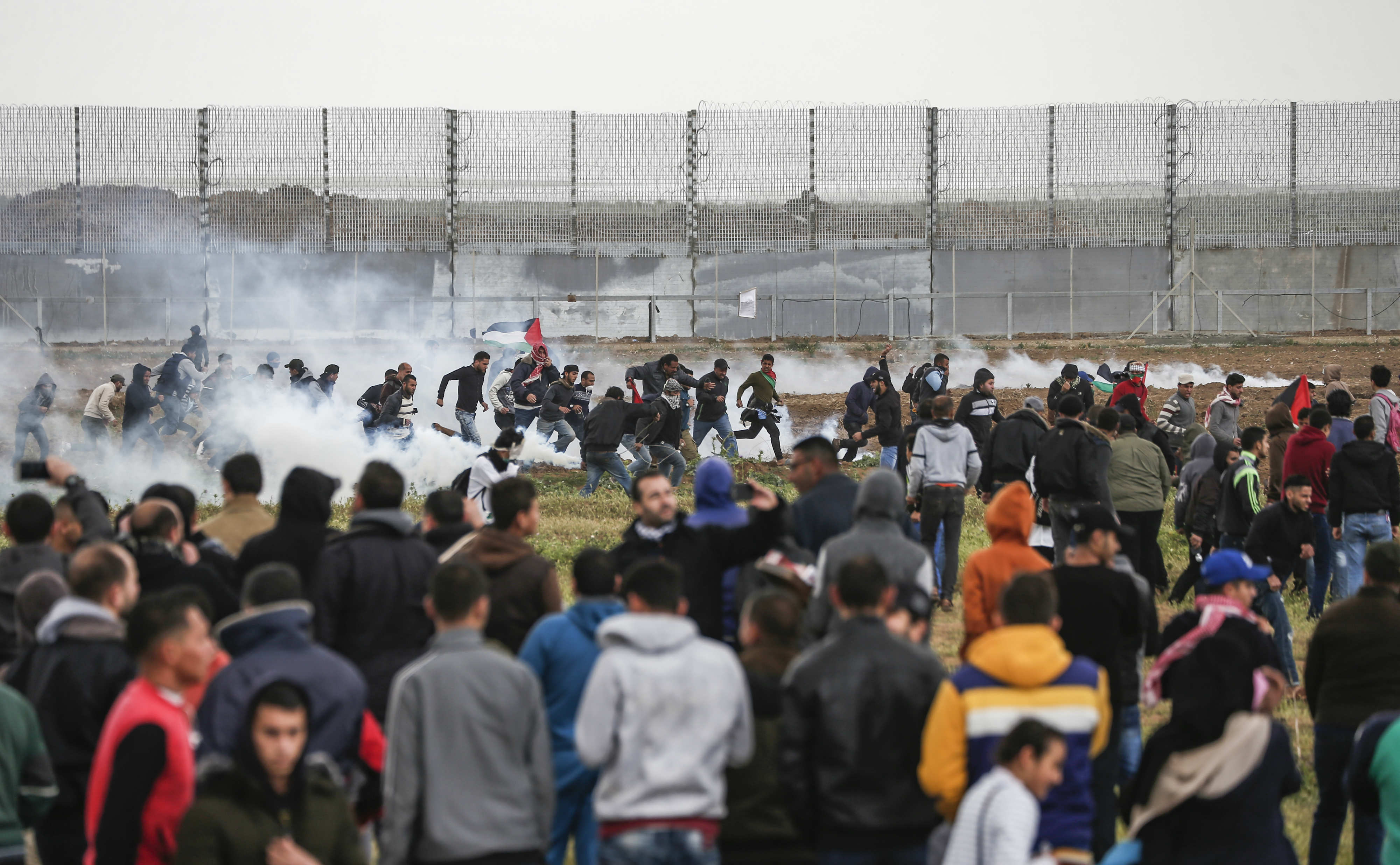 Palestinian protesters flee from tear gas fumes near the frontier with Israel in Malaka east of Gaza City (AFP)