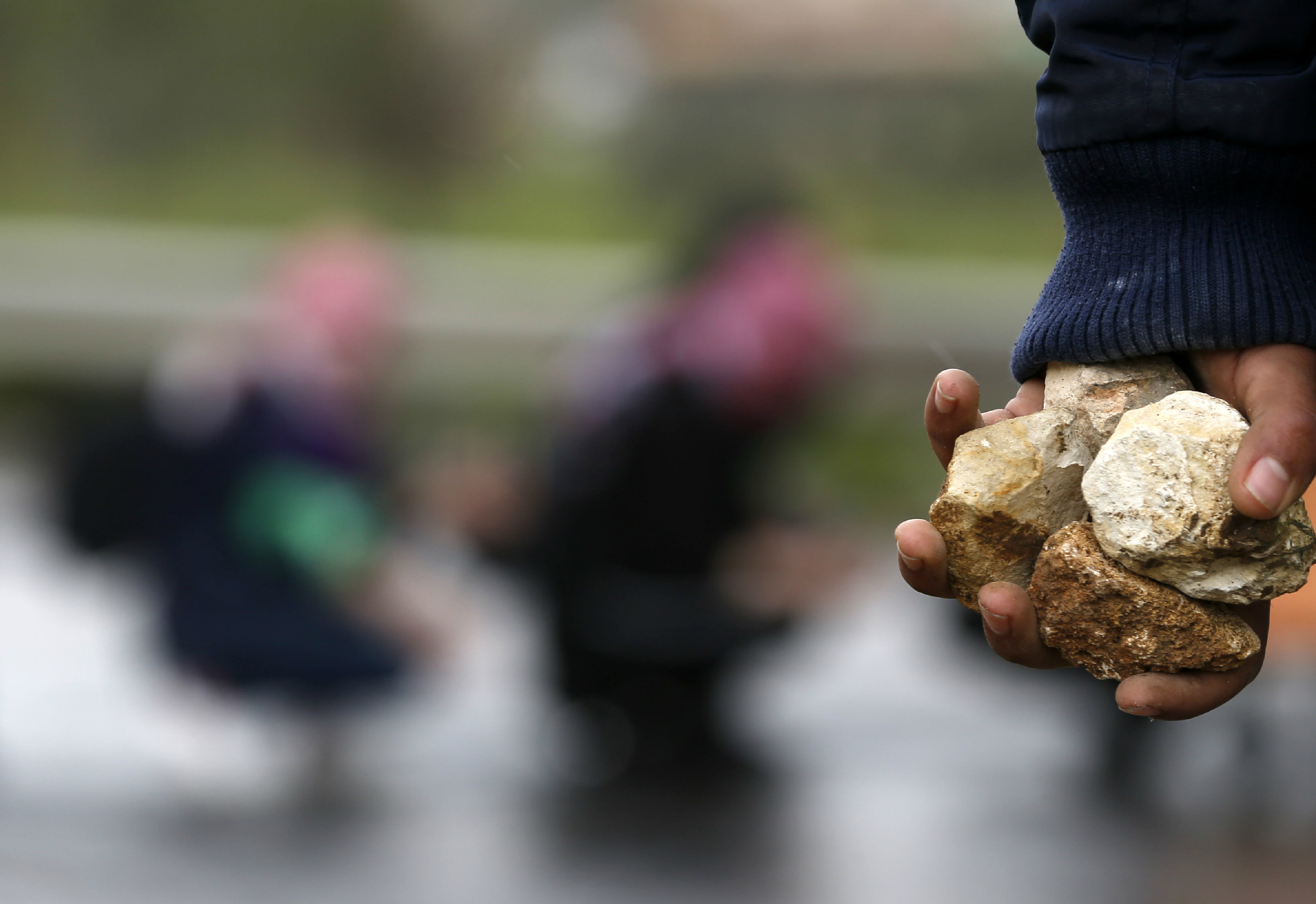 A Palestinian man carries stones during a demonstration marking Land Day in the West Bank (AFP)