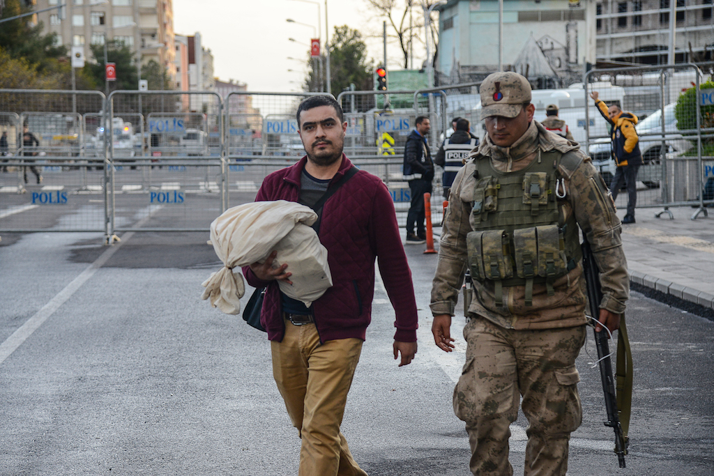 Electoral officers carry ballots after being counted at a polling station in Diyarbakir, Turkey