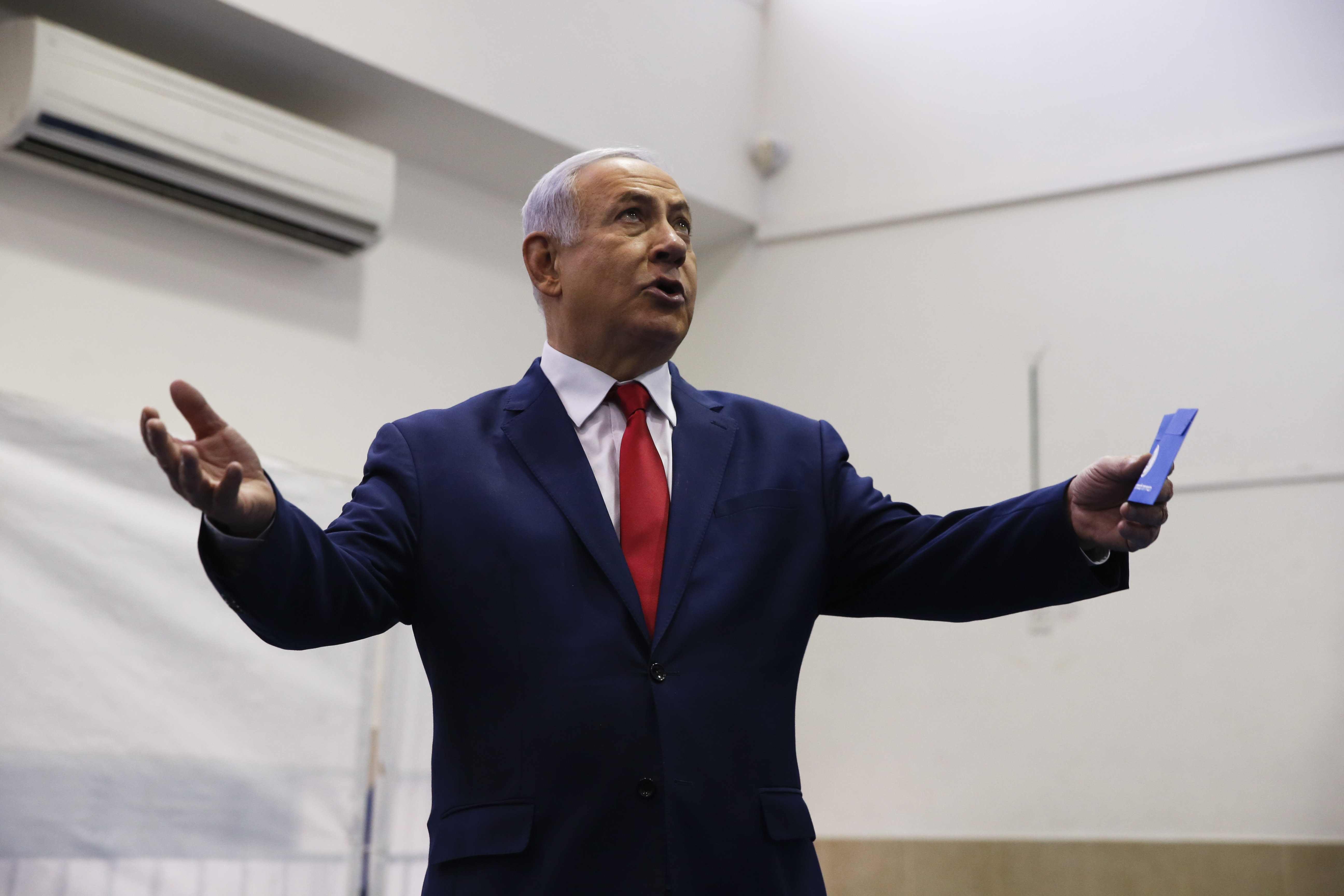 Israeli Prime Minister Benjamin Netanyahu prepares to cast his vote during Israel's parliamentary elections in Jerusalem (AFP)