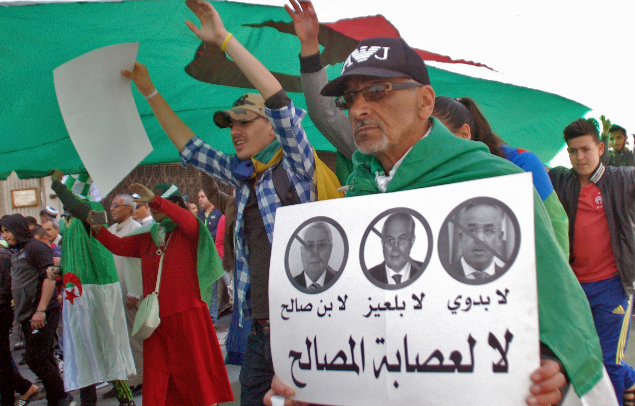 An Algerian man marches with a sign against the 