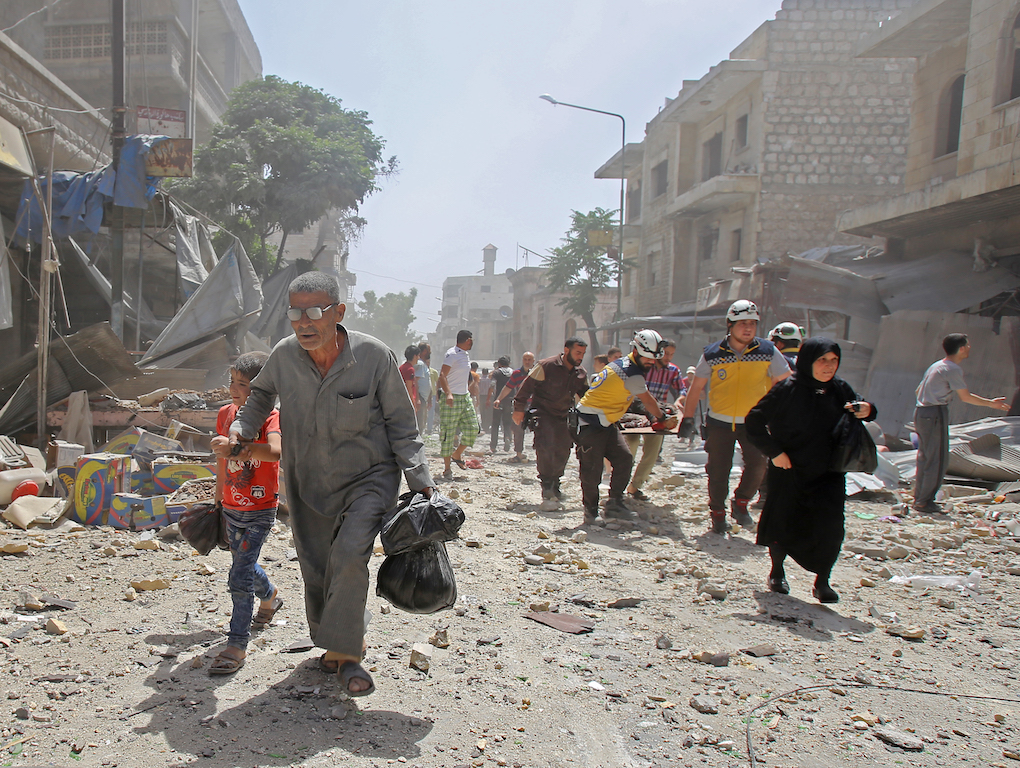 Members of the Syrian Civil Defence (known as the White Helmets) carry a wounded man on a stretcher following a reported air strike on the town of Maaret al-Numan (AFP)