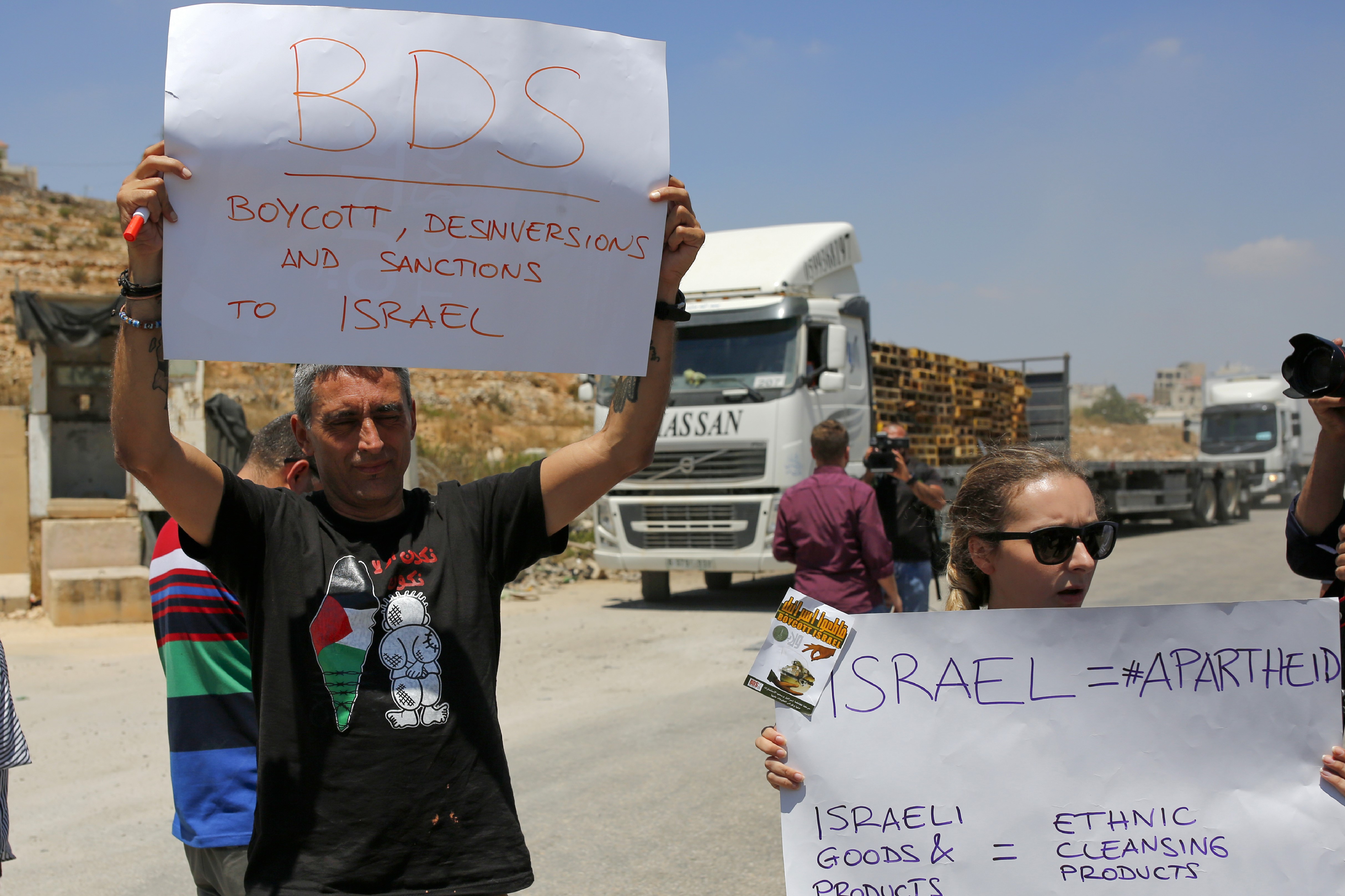 Palestinians demonstrate at the Ofer Israeli checkpoint near Ramallah, calling on Palestinians to boycott Israeli goodson 6 August (AFP)
