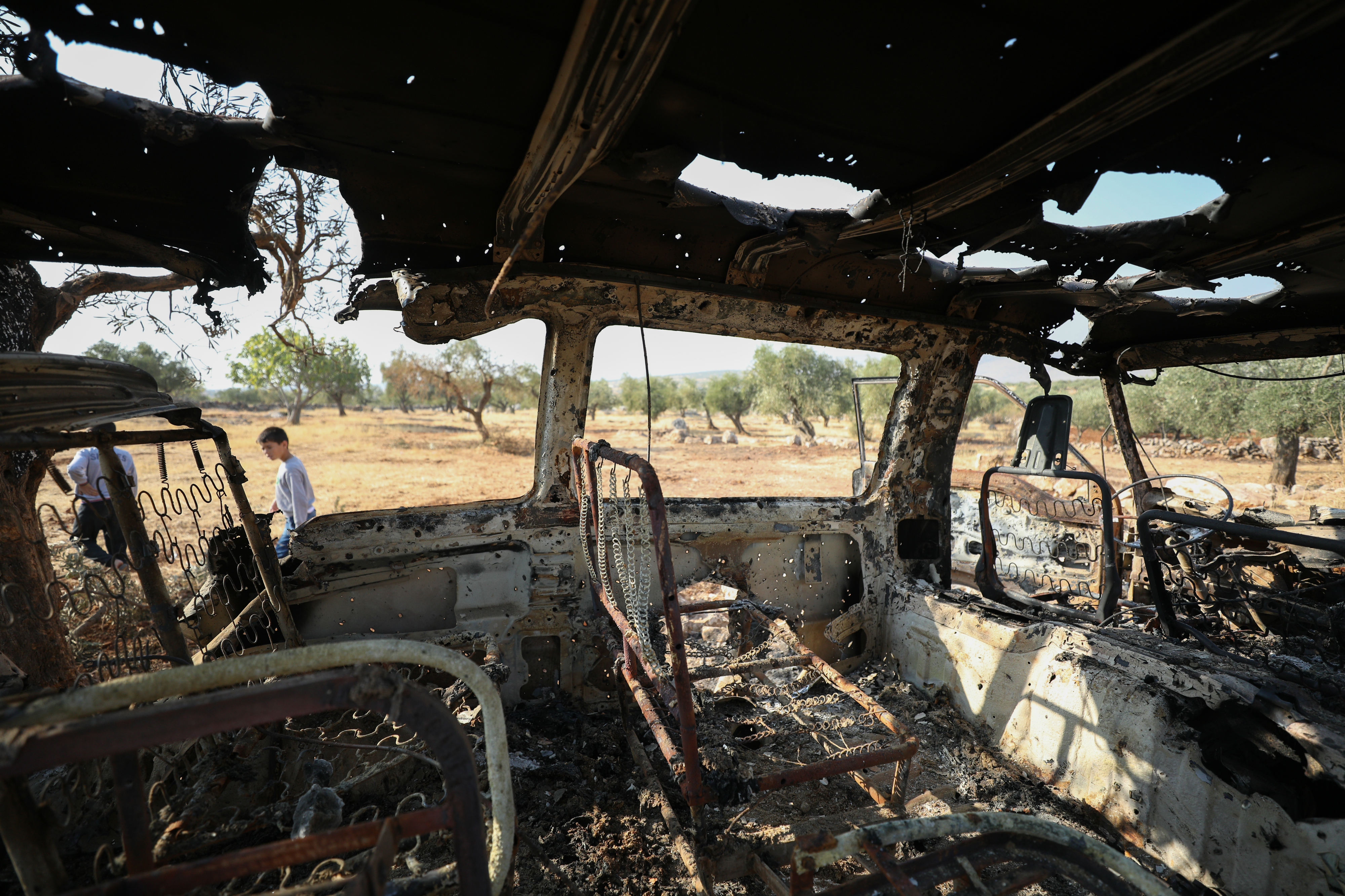 A burnt vehicle near the site of the US raid in Idlib (AFP)