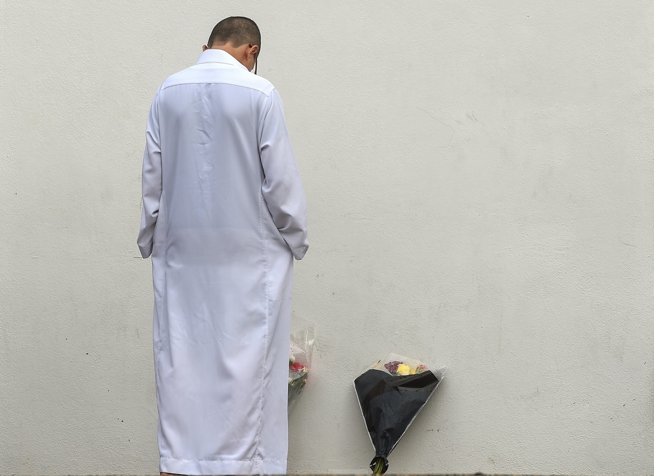 Un homme se recueille devant la mosquée de Bayonne le 1er novembre 2019, quelques jours après qu’un militant d’extrême droite, Claude Sinke, a tenté d’y mettre le feu et blessé grièvement deux personnes (AFP)