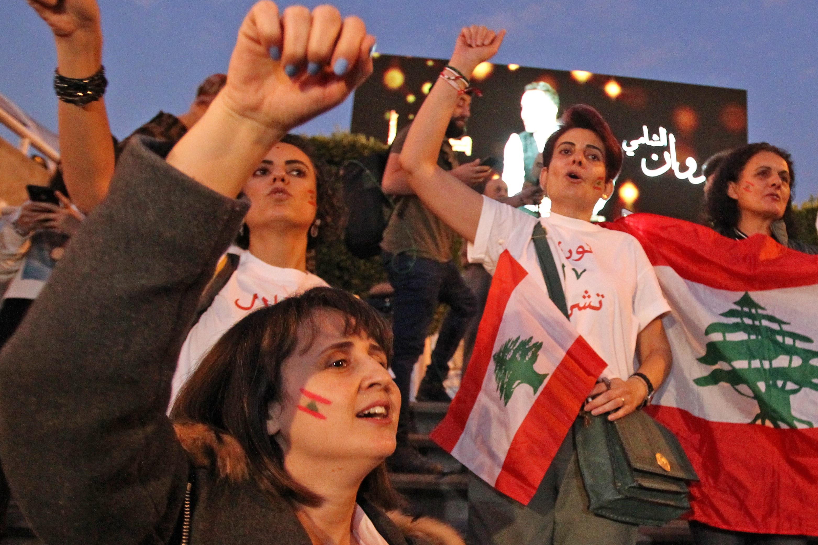 Lebanese expats are welcomed by demonstrators upon their arrival at the Beirut International Airport in the Lebanese capital on 22 November (AFP)