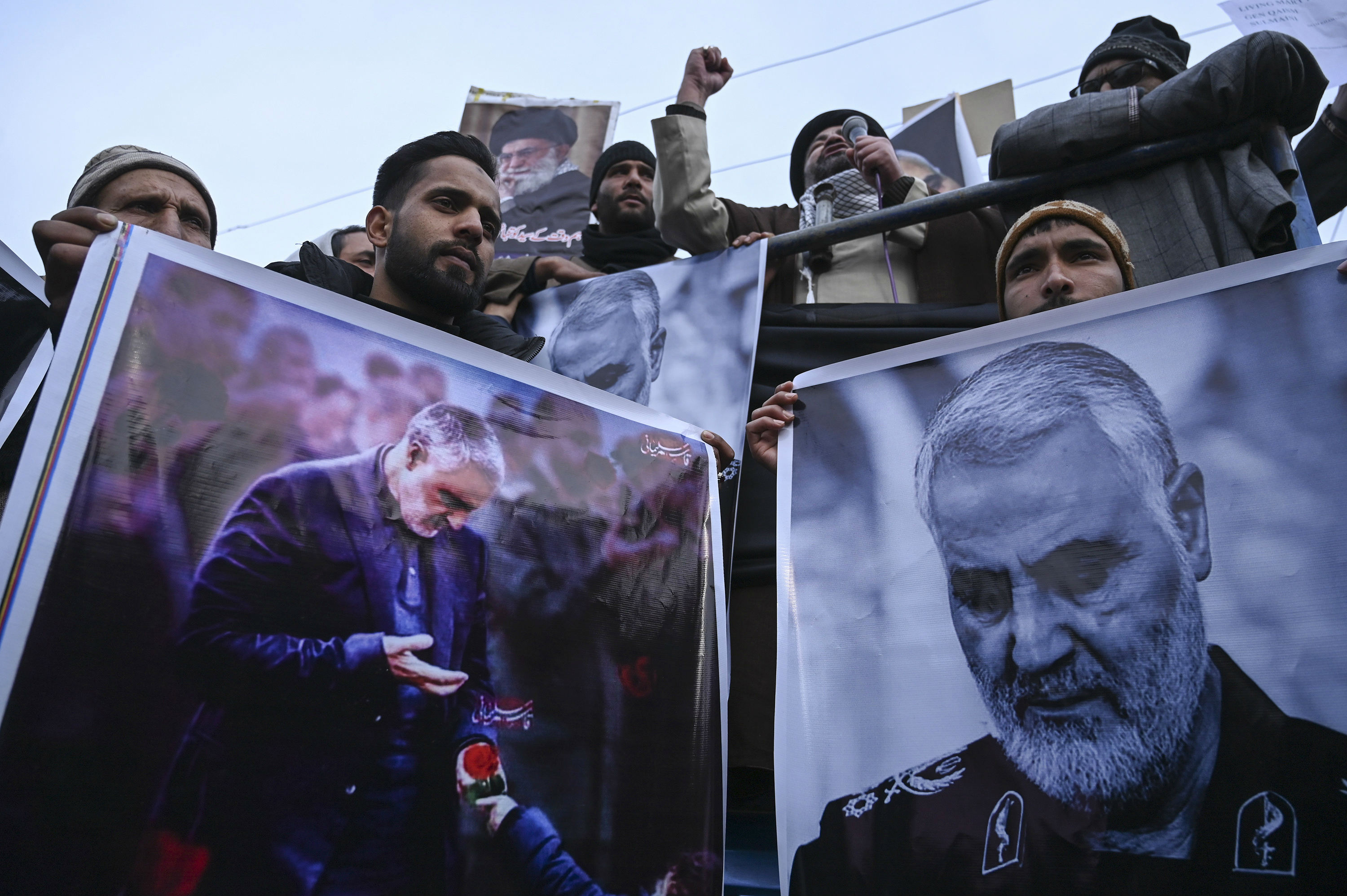 Protesters shout slogans against the United States and Israel as they hold posters with the image of top Iranian commander Qasem Soleimani (AFP)