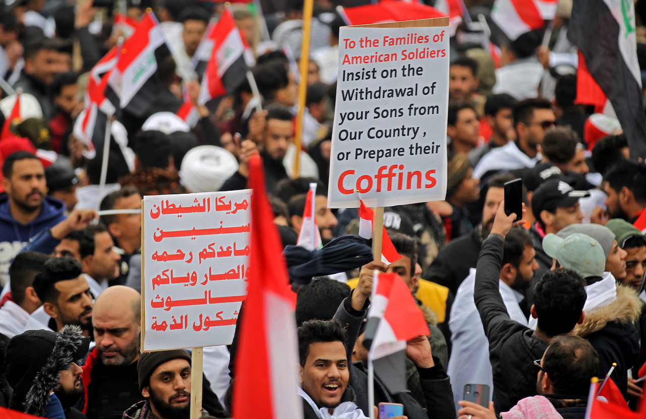 Protesters raise placards as supporters of Iraqi cleric Moqtada Sadr gather in the capital Baghdad for a 