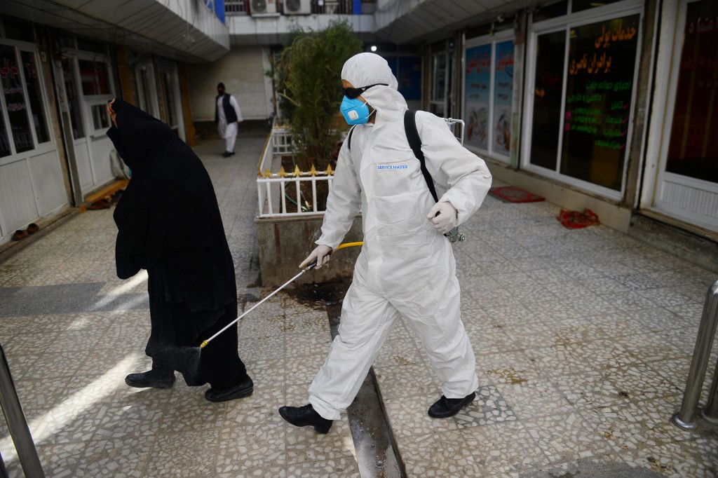 A health services staffer sprays disinfectant in a market in Herat city as a preventive measure against the spread of the coronavirus (AFP)