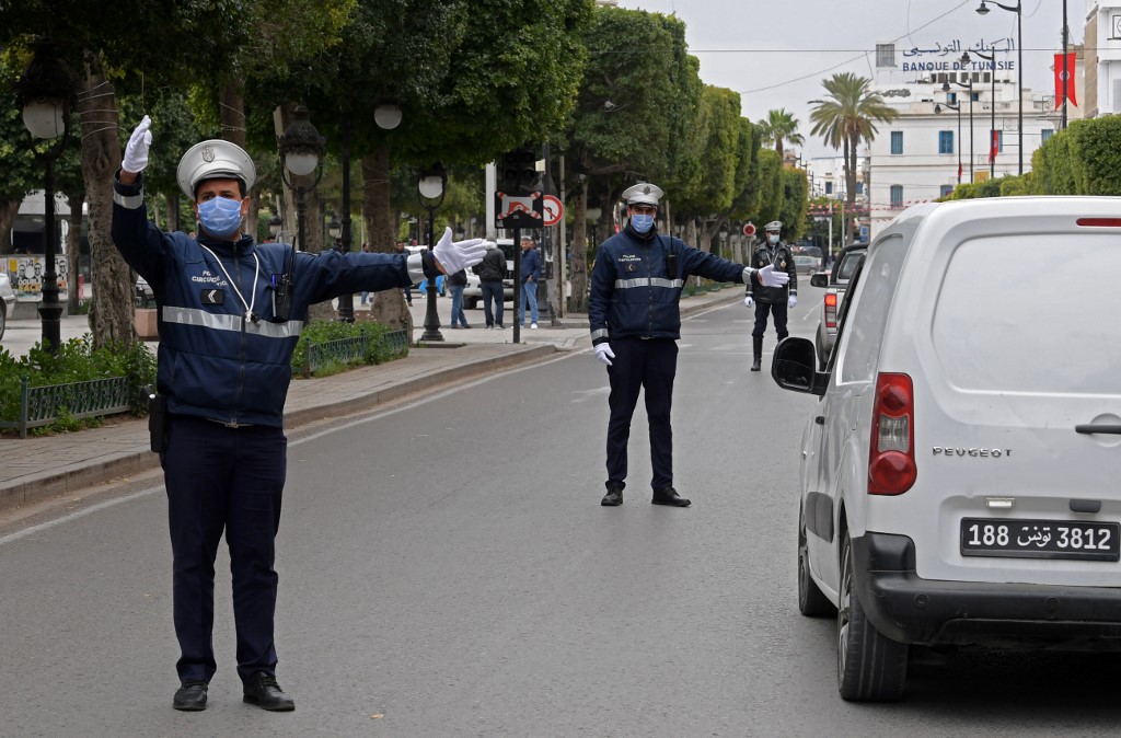 Des policiers inspectent les véhicules avenue Habib Bourguiba à Tunis le 24 mars 2020 pour interdire tout rassemblement de plus de trois personnes dans les rues en raison de l’épidémie de coronavirus (AFP)