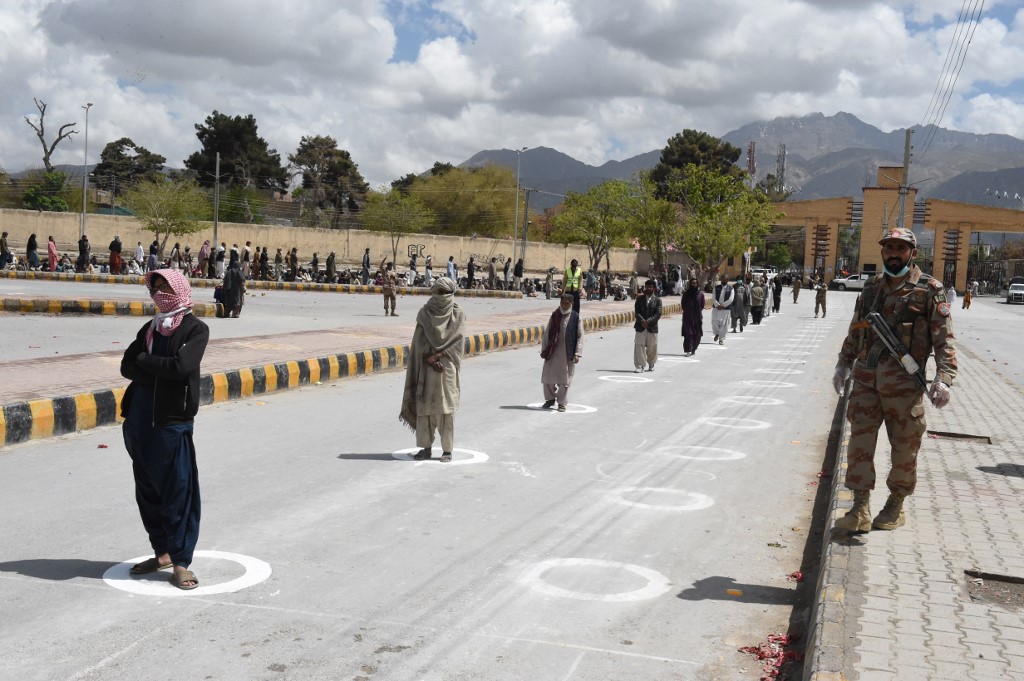 In Quetta, people waiting to collect rations from a welfare trust maintain social distancing (AFP)