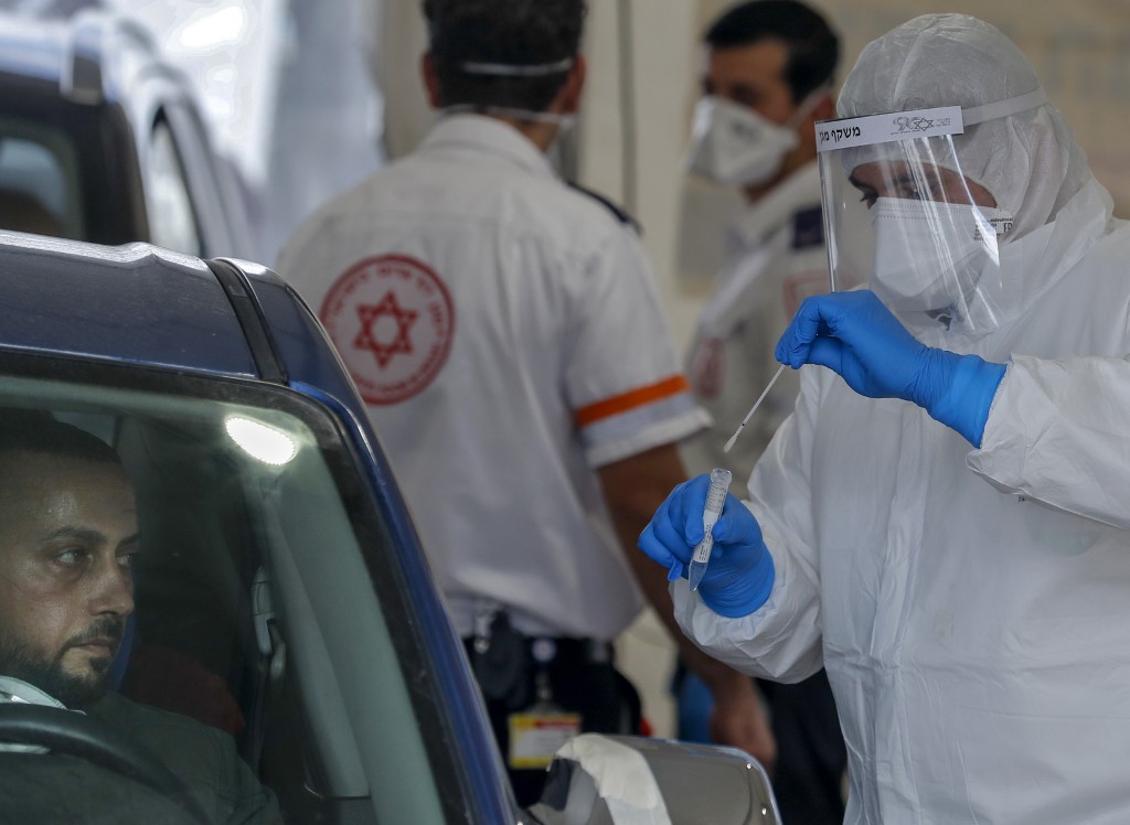Un ambulancier de Magen David Adom réalise un test pour le COVID-19 dans le quartier palestinien de Jabel Mukaber à Jérusalem-Est annexée, le 2 avril 2020 (AFP)