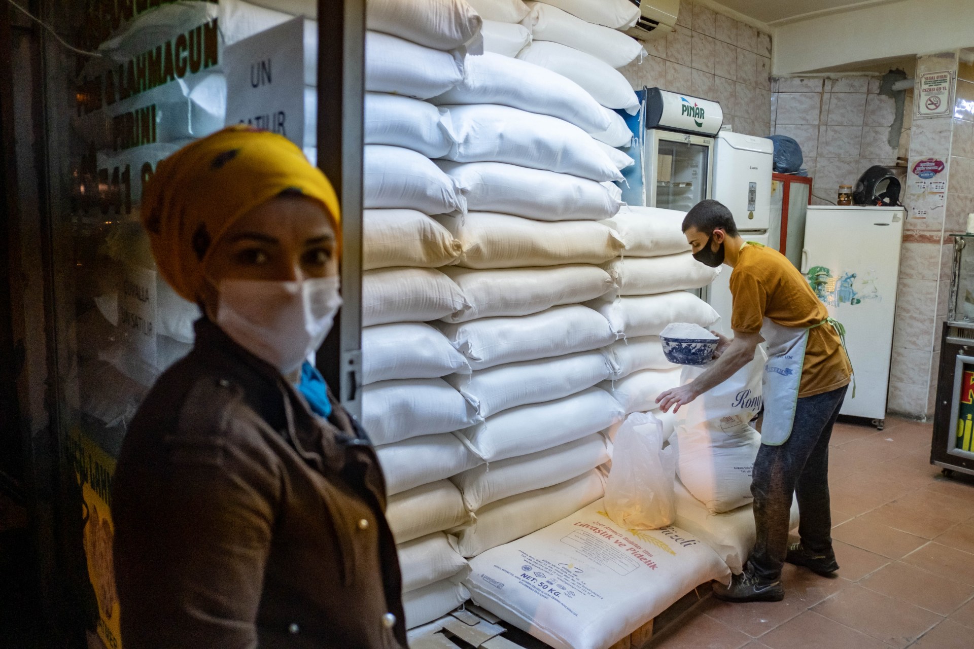 A Turkish customer waits outside a shop to buy flour, shortly before the curfew in Istanbul (AFP)