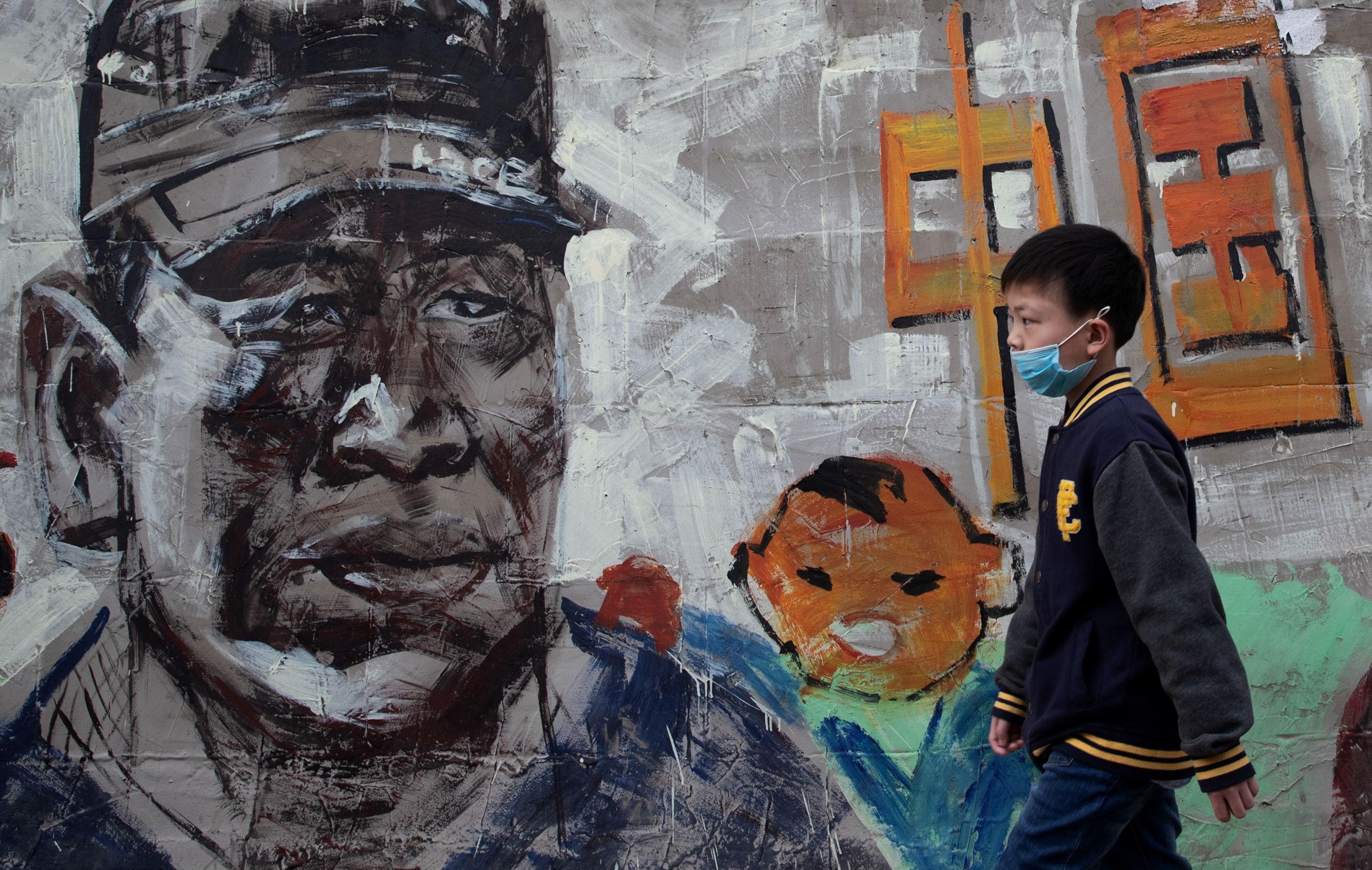 A boy wearing a face mask amid concerns of the COVID-19 coronavirus walks along a street in Wuhan, in China's central Hubei province on April 24, 2020.