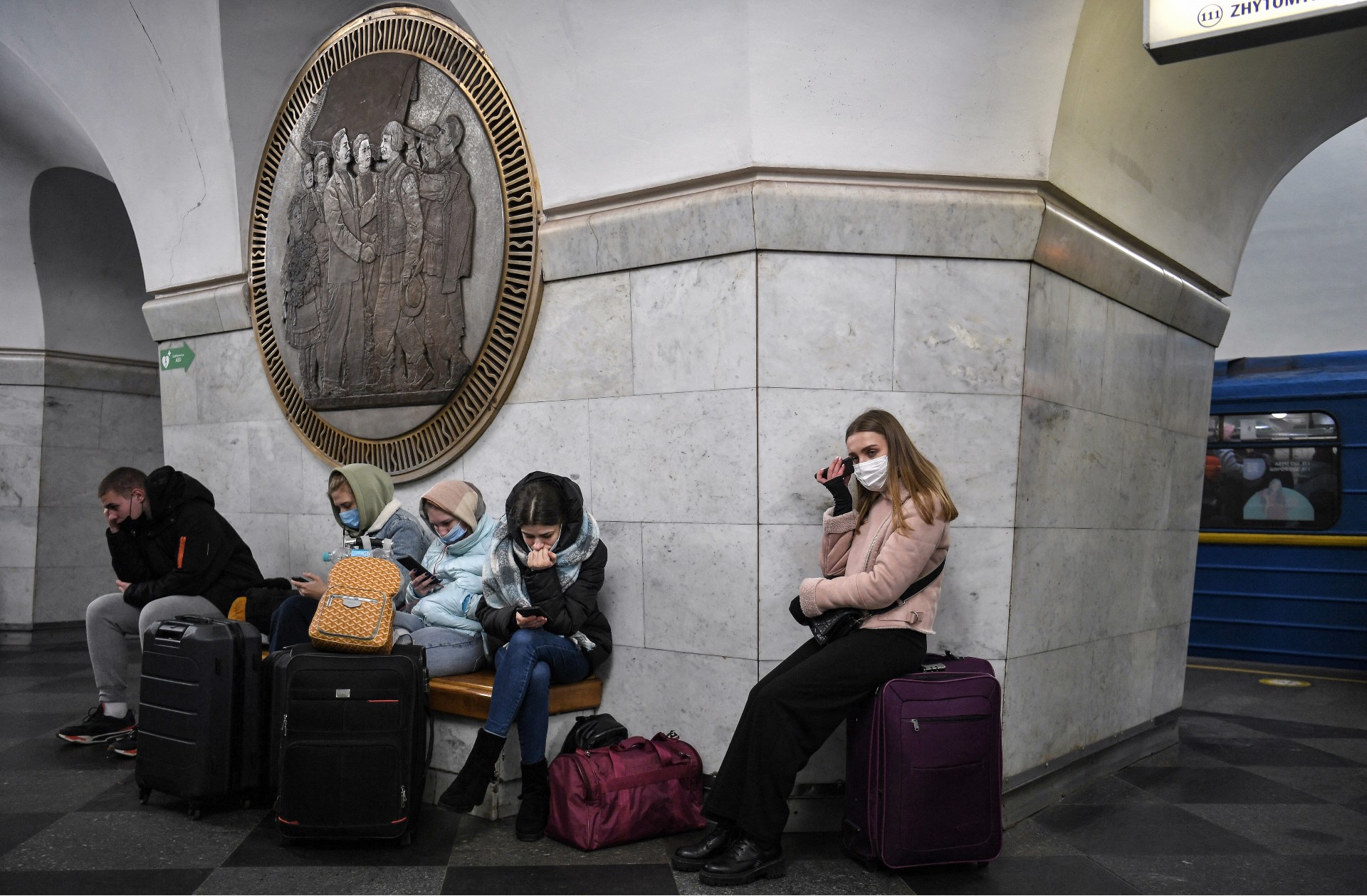 People use their phone as they take shelter in a metro station in Kyiv (AFP)