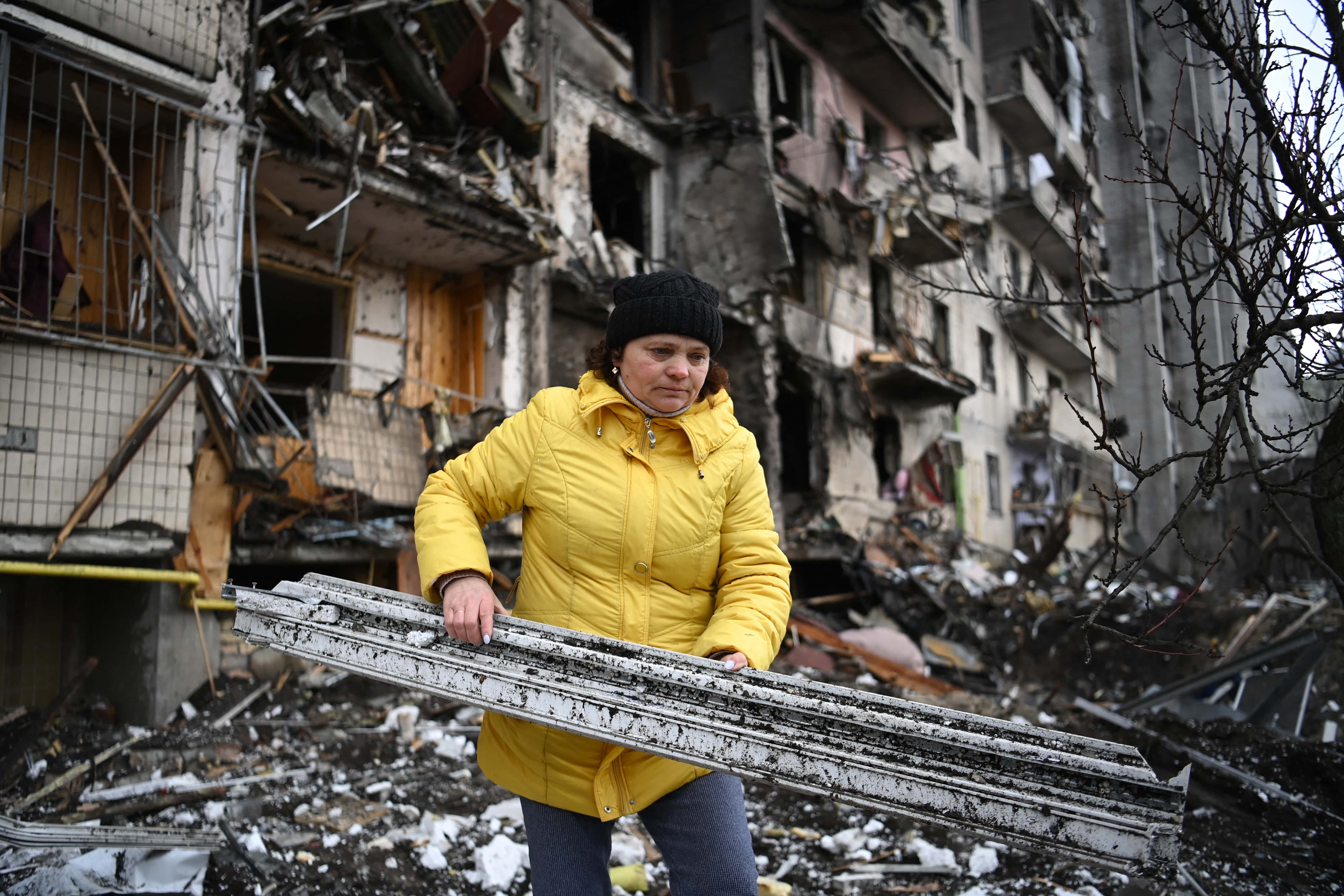 woman clears debris ukraine