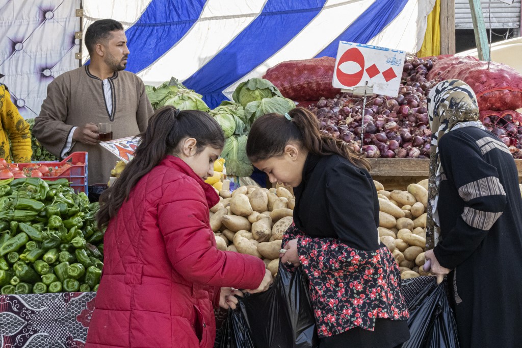 People shop at a stall in a public market in el-Arish city, in the northern Sinai Peninsula, on March 20, 2022.