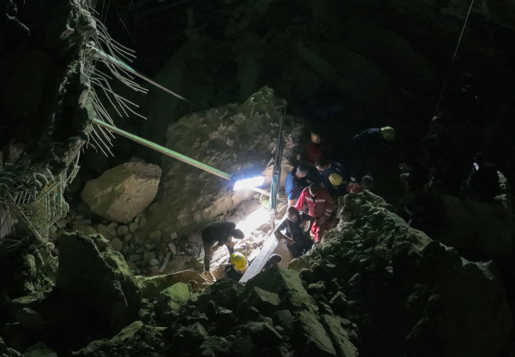 An aerial picture shows members of Iraqi emergency services scanning the rubble for victims following a landslide at the Qattarat al-Imam Ali shrine on the outskirts of the holy city of Karbala (AFP)