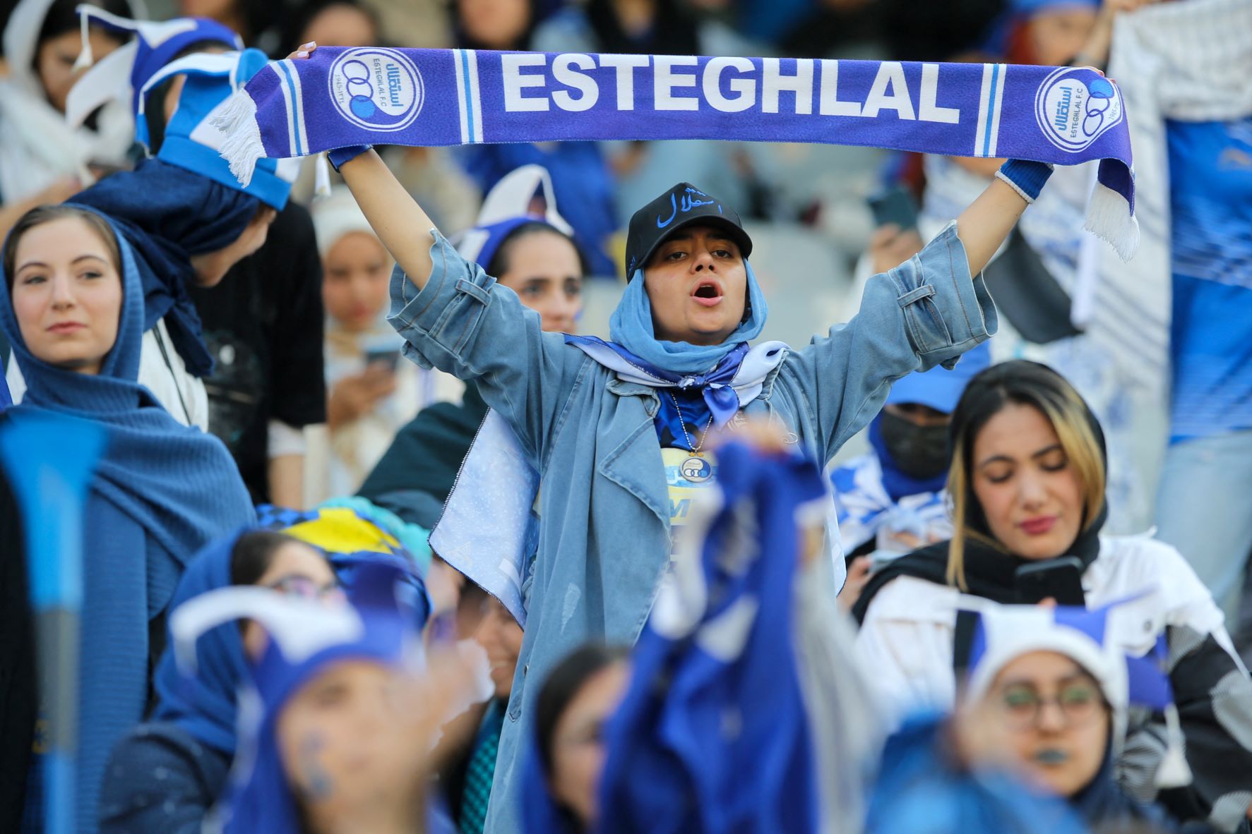 Iranian women fans of Esteghlal football club cheer during a match between Esteghlal and Mes Kerman at the Azadi stadium in the capital Tehran, on August 25, 2022 (AFP)
