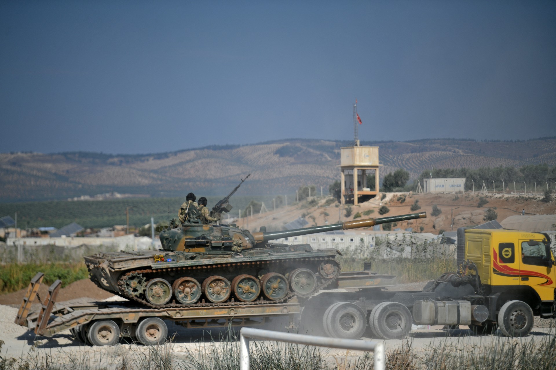 Members of Hay'at Tahrir al-Sham bring reinforcements on the outskirts of the Afrin region of Syria's rebel-held northern Aleppo province, 13 October (AFP)