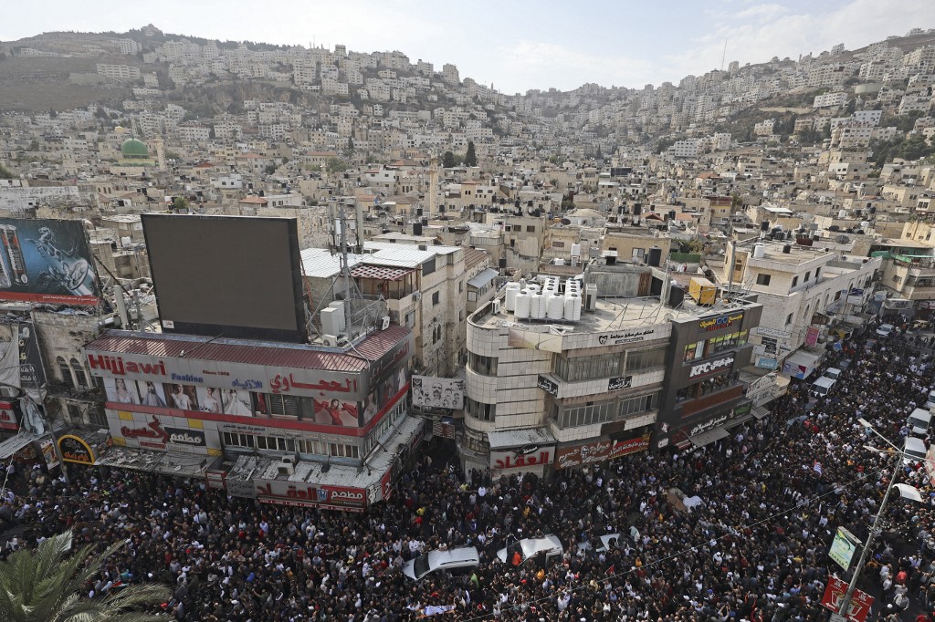 Thousands of mourners attend the funeral of Palestinians killed in an overnight Israeli raid, in the occupied West Bank city of Nablus on 25 October 2022 (AFP)