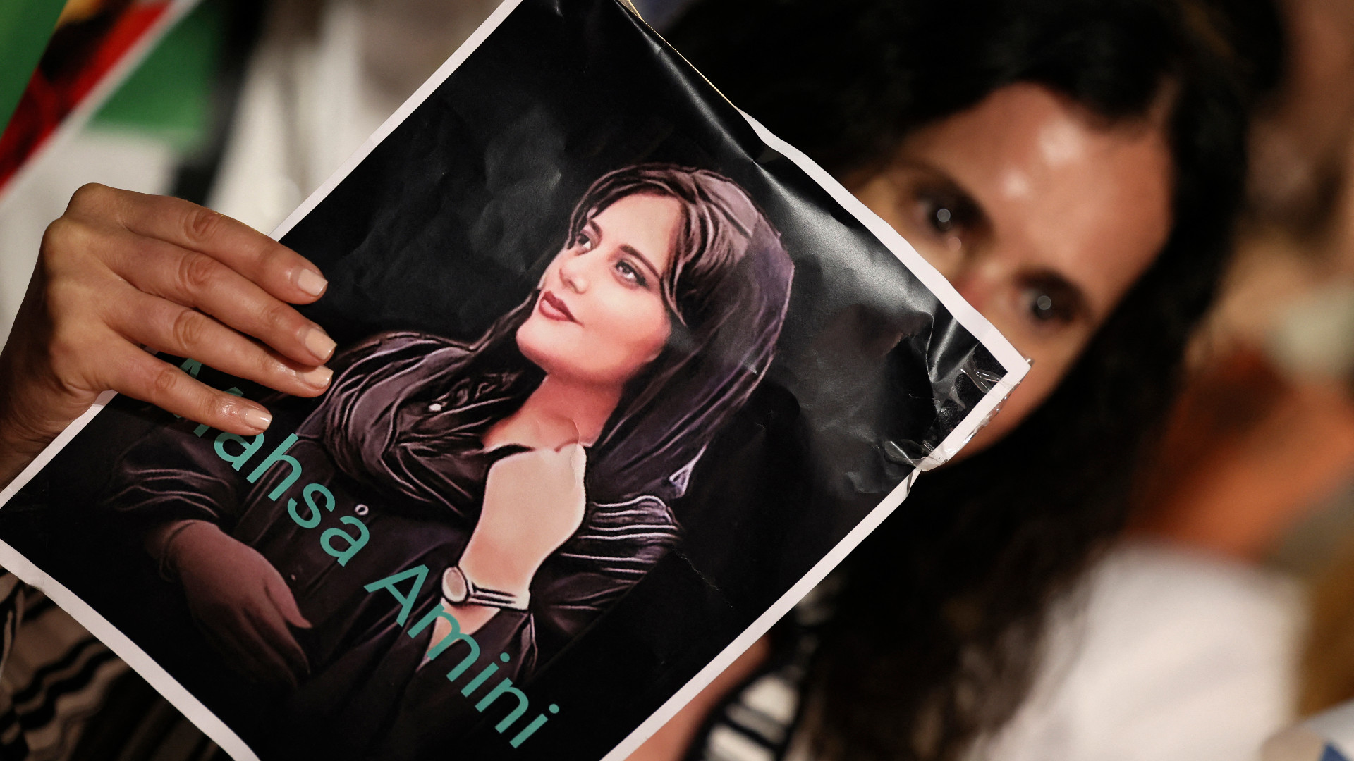 A protester carries a portrait of Masha Amini, during a demonstration in support of Iran protests in the Israeli coastal city of Tel Aviv on 29 October, 2022. (AFP)