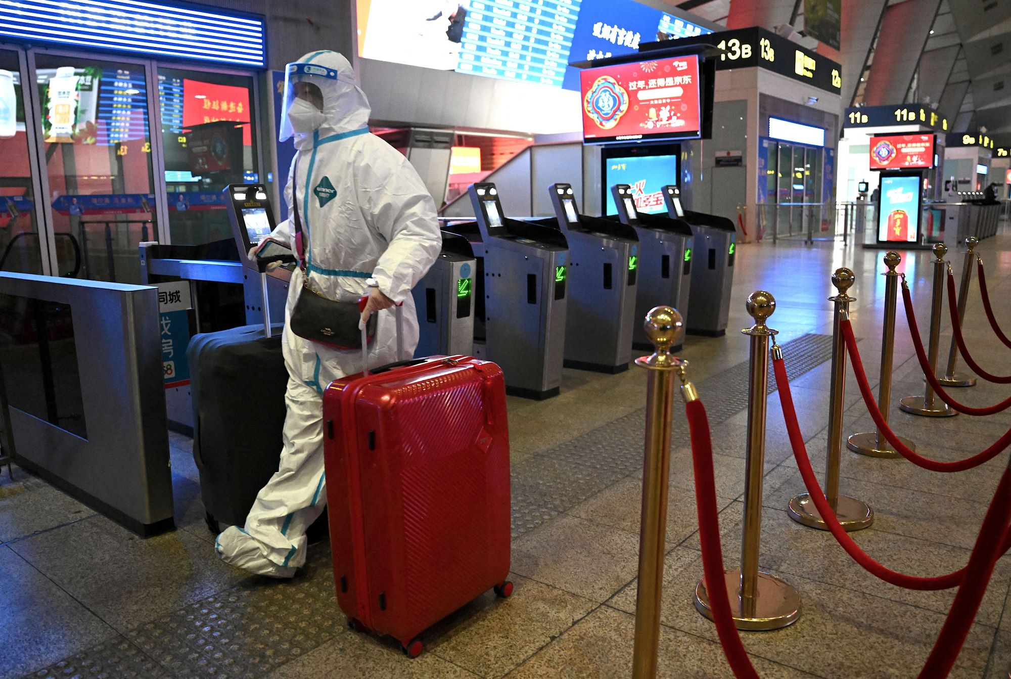 A passenger wearing personal protective equipment to halt the spread of Covid-19 arrives at a train station in Beijing on January 5, 2023 (AFP)