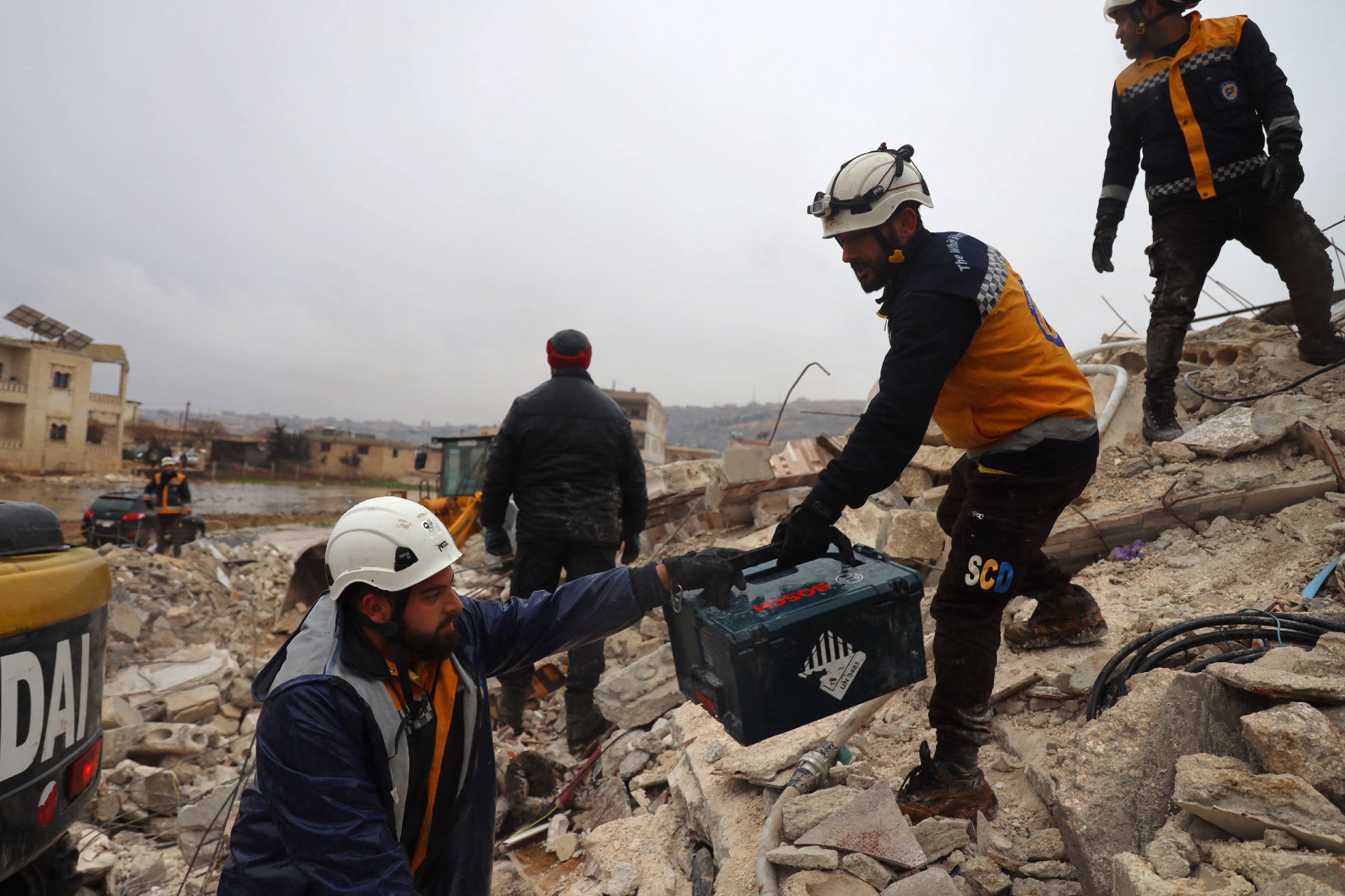 Members of the Syrian Civil Defence, known as the White Helmets look for casualties under the rubble following an earthquake in the town of Sarmada (AFP)