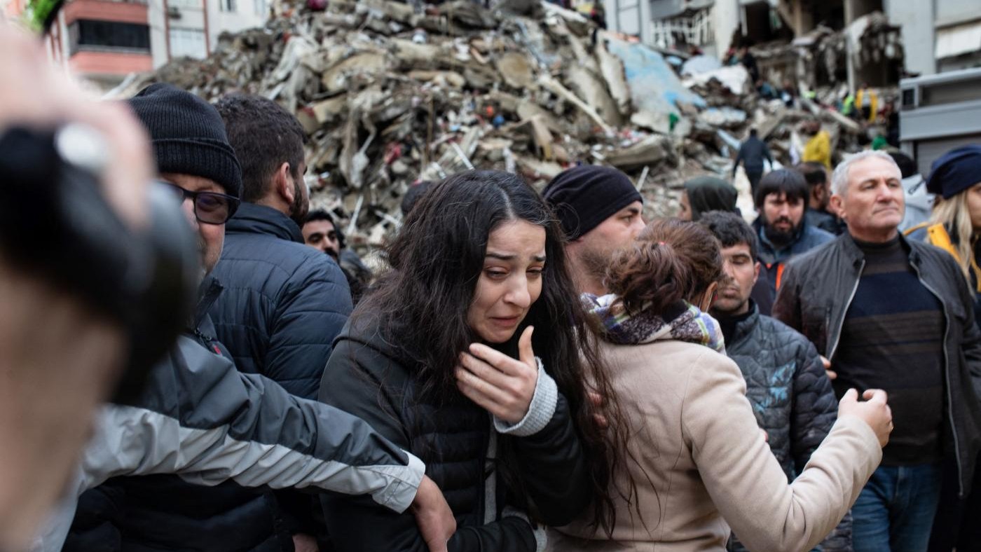 A woman reacts as rescuers search for survivors through the rubble of collapsed buildings in Adana, on 6 February 2023 after a 7.8 magnitude earthquake struck the country.