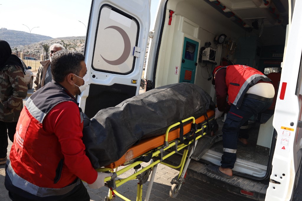 Rescue teams transport the bodies of Syrians killed in an earthquake in Turkey following their repatriation though the opposition-held crossing of Bab al-Hawa, at the border with Turkey in the northern Aleppo province, on February 12, 2023. Ahmad al-ATRASH / AFP