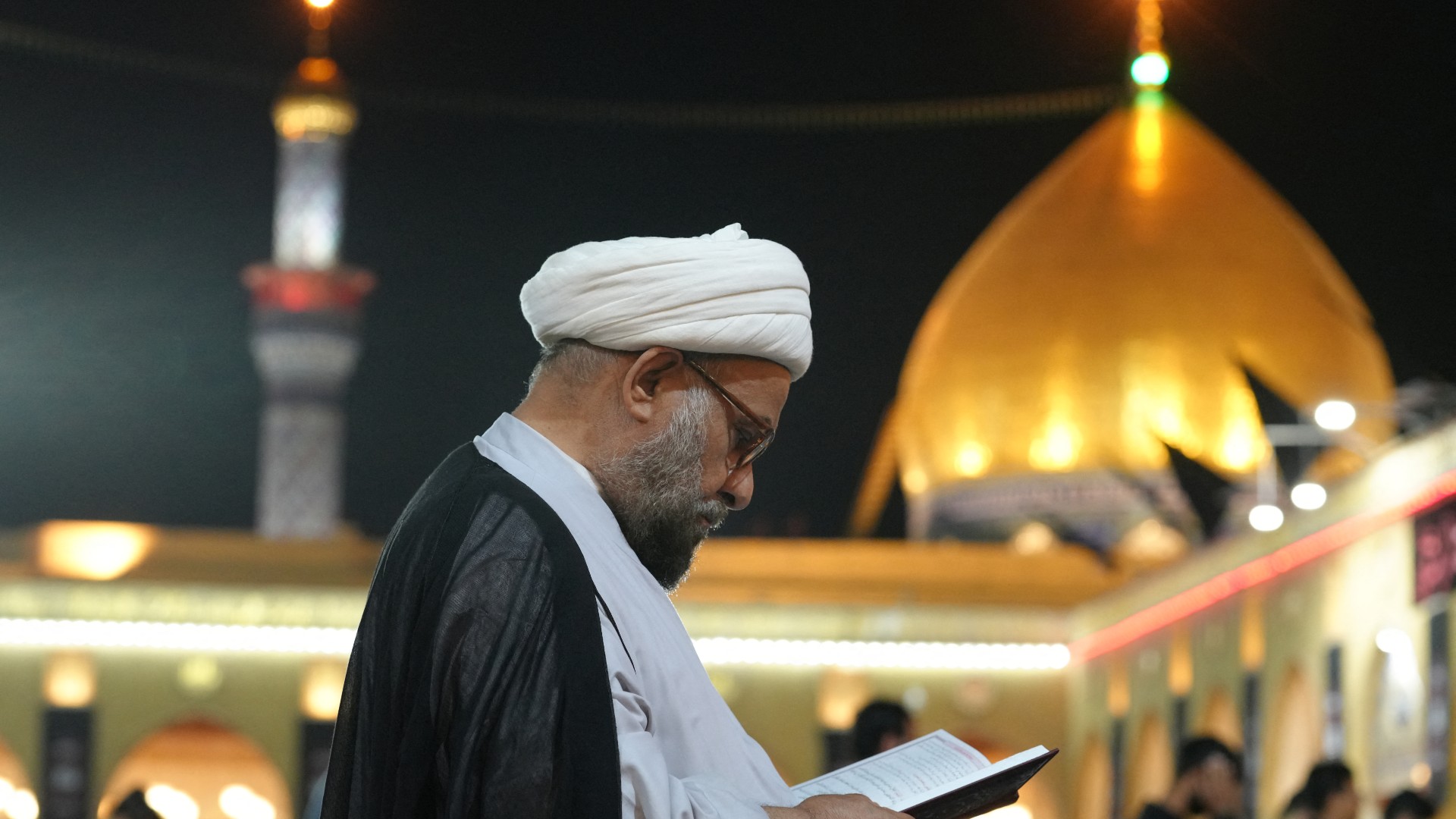 A devotee reads the Quran during Ramadan at the Grand Mosque of Kufa, 14 April (AFP)