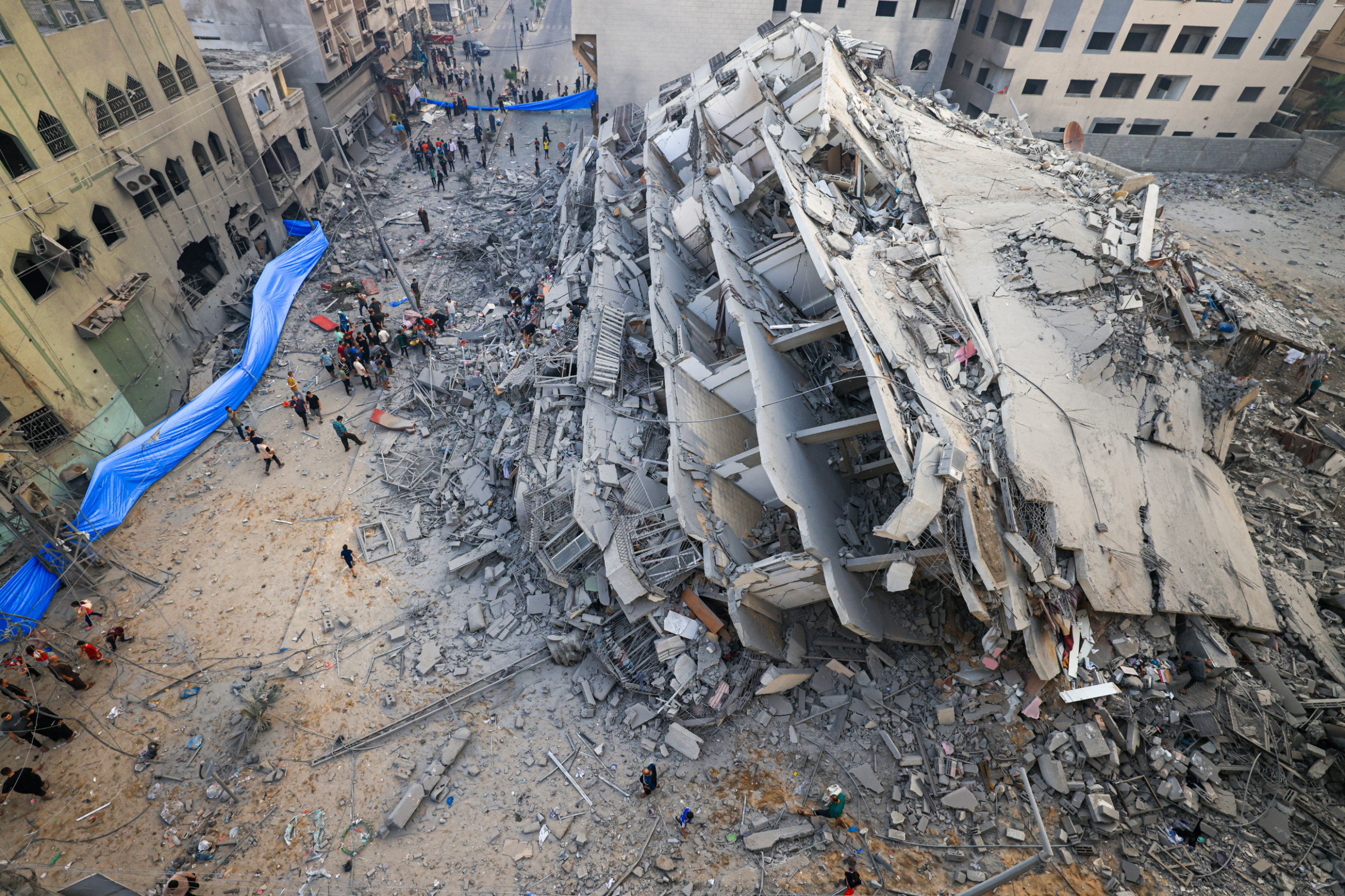 People inspect the ruins of a building destroyed in Israeli strikes in Gaza City on 8 October 2023 (AFP)