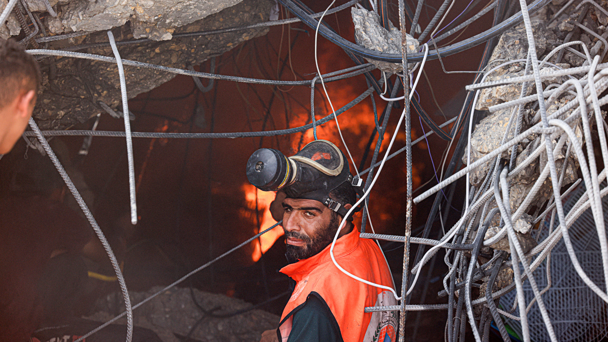 Palestinian rescue teams work under the rubble of a collapsed building following an Israeli strike, in Khan Yunis in the southern Gaza Strip on 14 October 2023 (AFP)