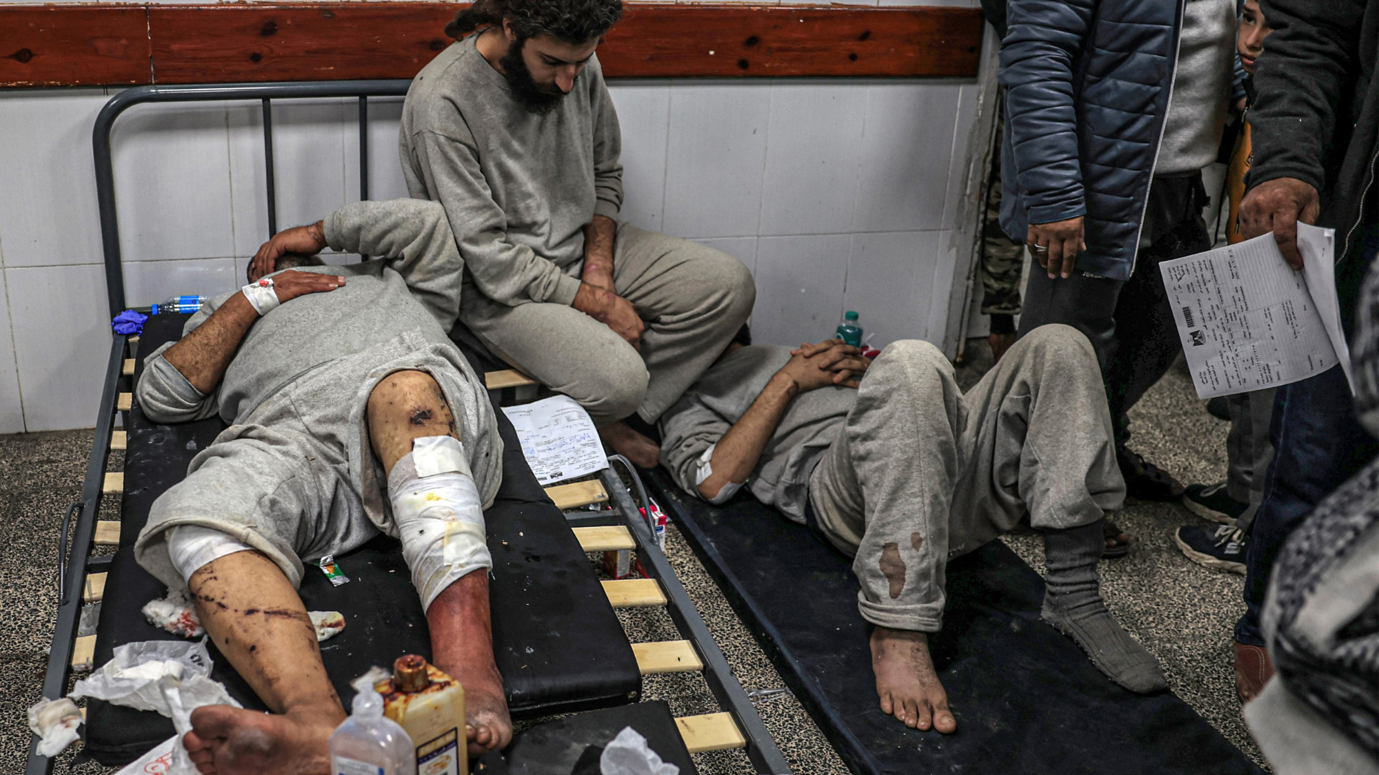 Men injured in Israeli detention pictured after their release at al-Najjar hospital in Rafah in the southern Gaza Strip on 24 December 2023 (AFP/Said Khatib)