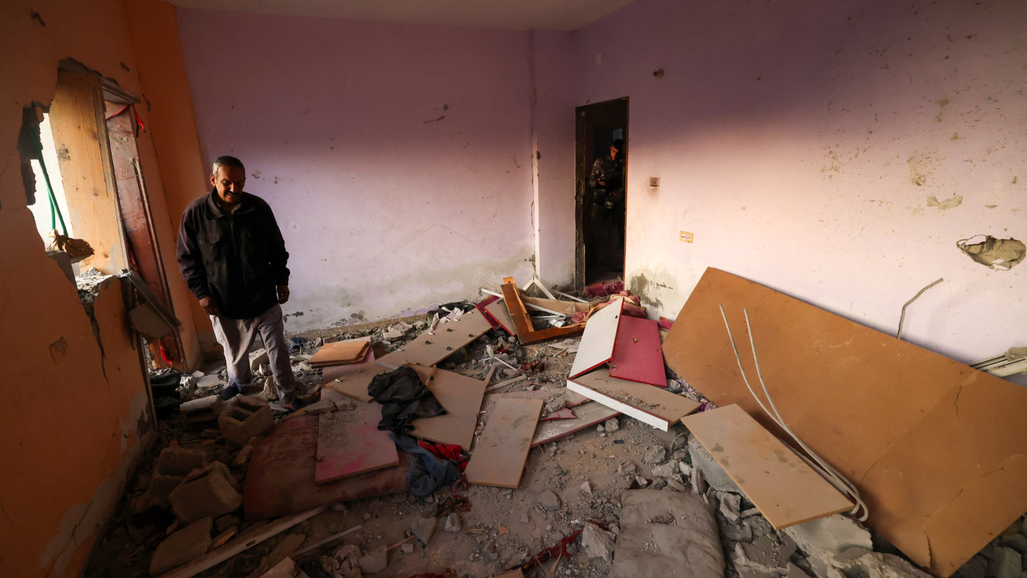 Men check a home destroyed by Israeli bombardment in Rafah refugee camp, south of the Gaza Strip, on 1 January 2024 (AFP)