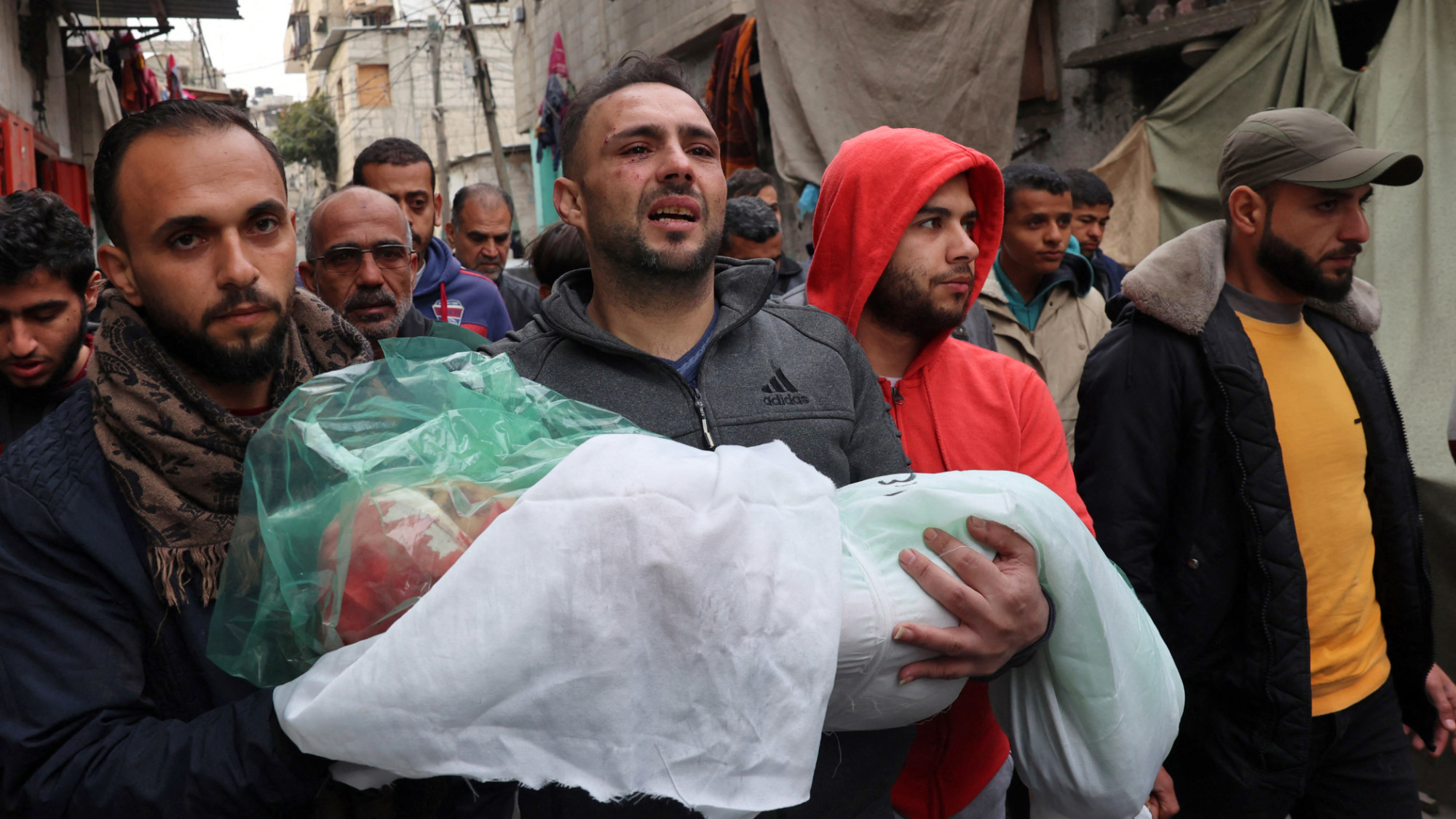 The father of Masa Shoman carries the body of his daughter who was killed in Israeli bombardment 17 January 2024 (AFP)