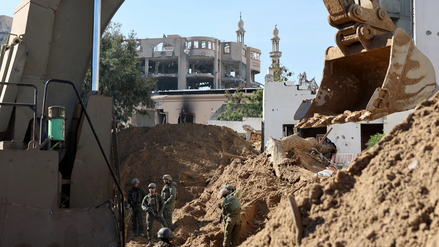 Israeli soldiers stand near a bulldozer inside Gaza City during a media tour organised by the military on 8 February 2024 (AFP/Jack Guez)