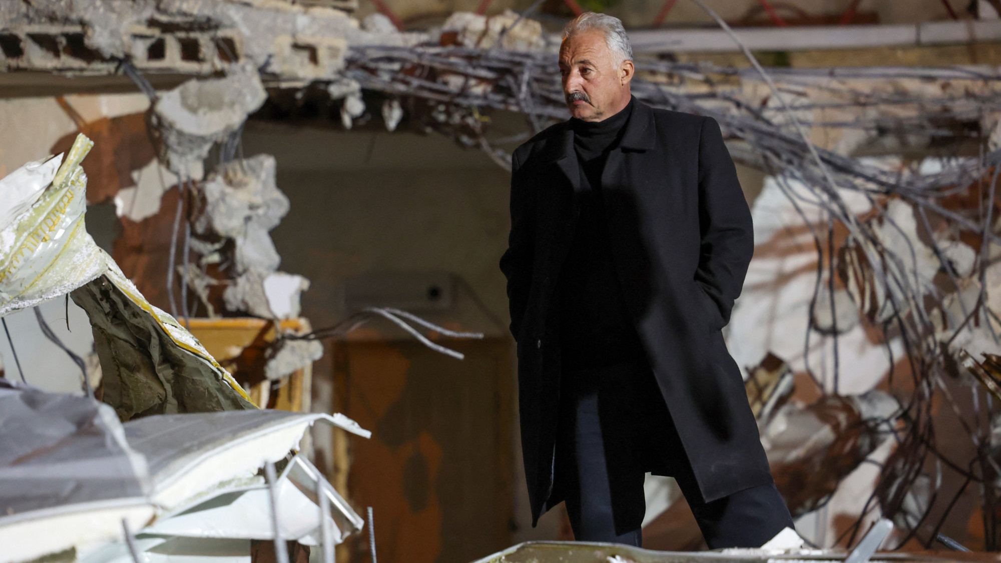 Fakhri Abu Diab stands amid the rubble of his home that was demolished by Israeli forces in the occupied East Jerusalem neighbourhood of Silwan on 14 February 2024 (AFP/Ahmad Gharabli)
