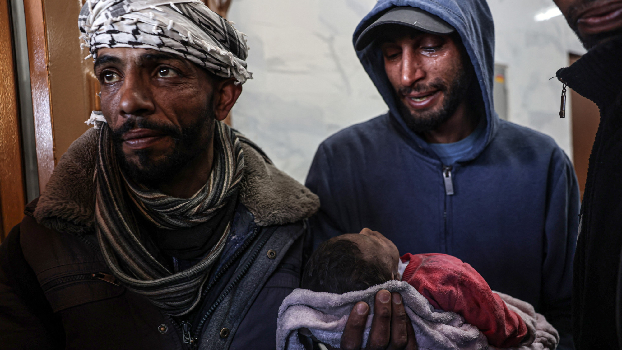 A relative carries the body of three-week old baby girl Sahar Musleh who was killed in the Israeli bombardment of al-Faqawi family home(Said Khatib/AFP)