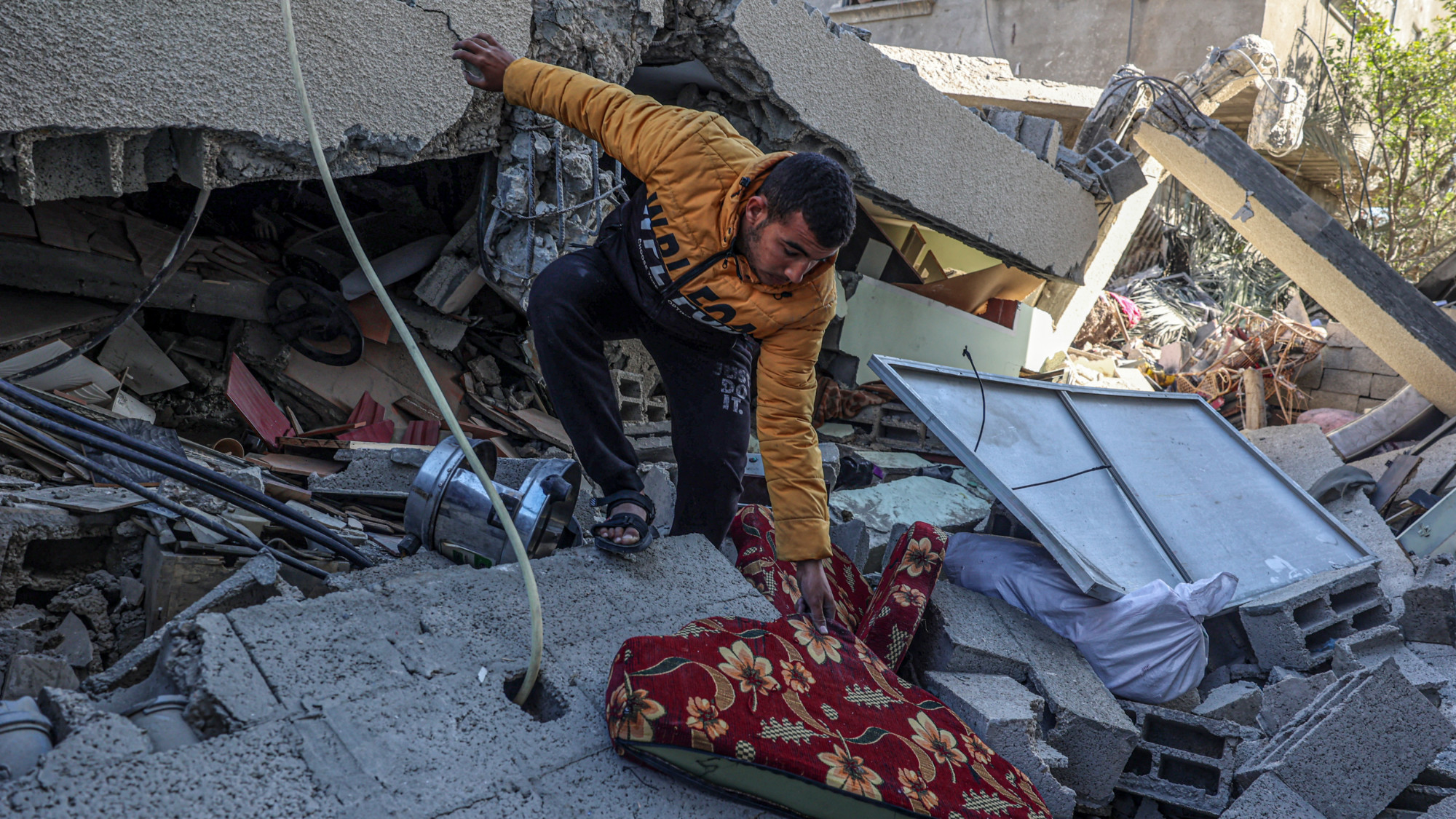 A man looks for salvageable items at the al-Faqawi family home after it was hit by Israeli fighter jets (Said Khatib/AFP)